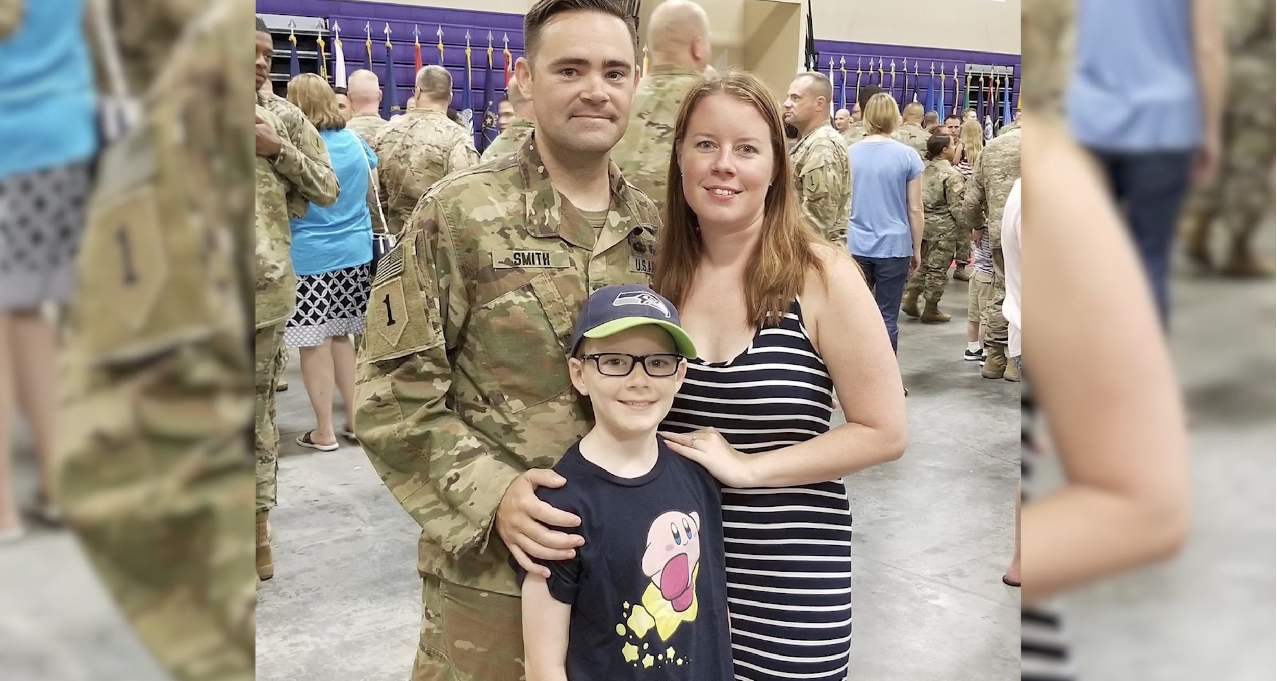 A man in an army uniform with a woman and child