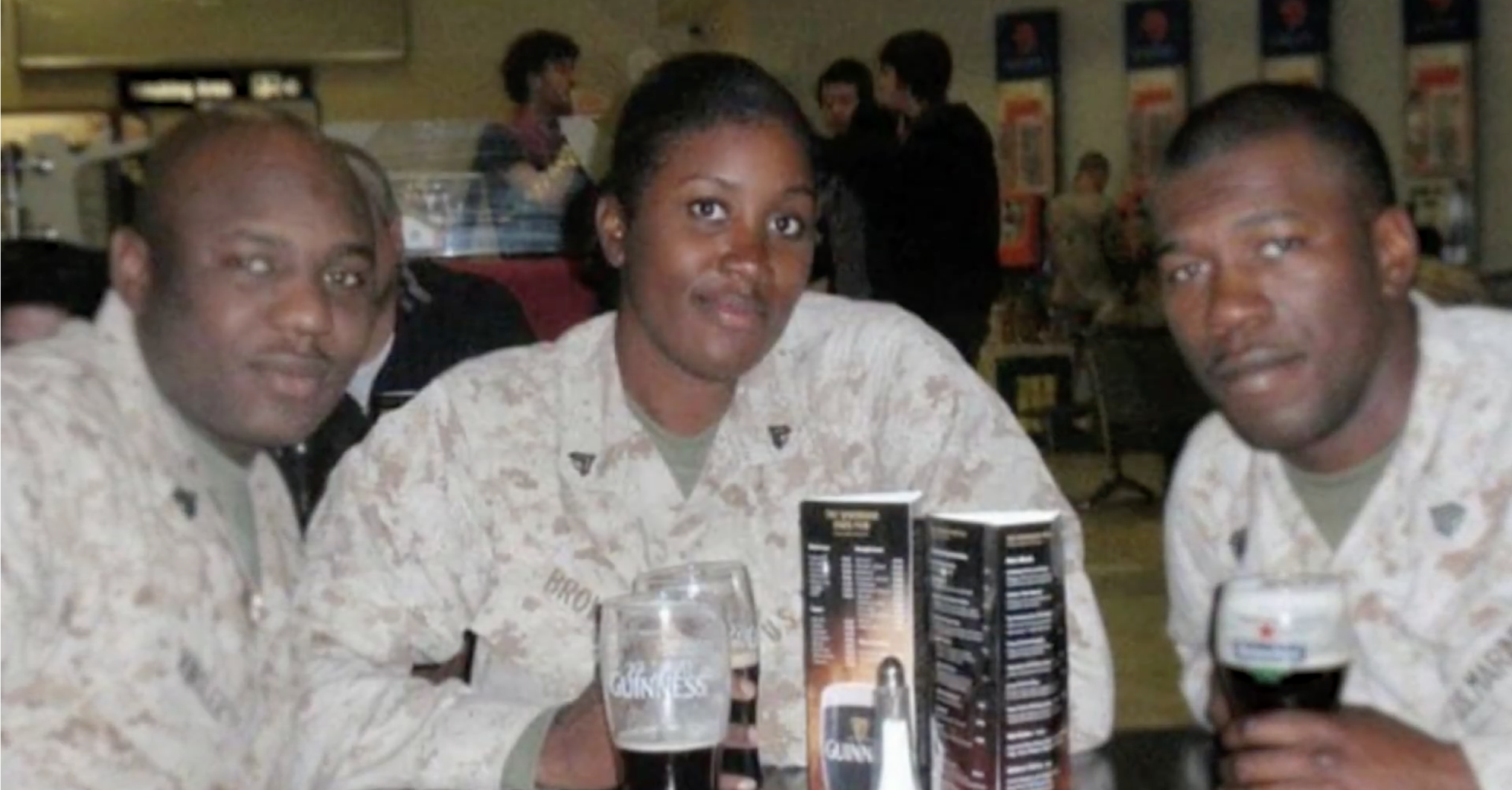 Three soldiers in fatigues sit at a table