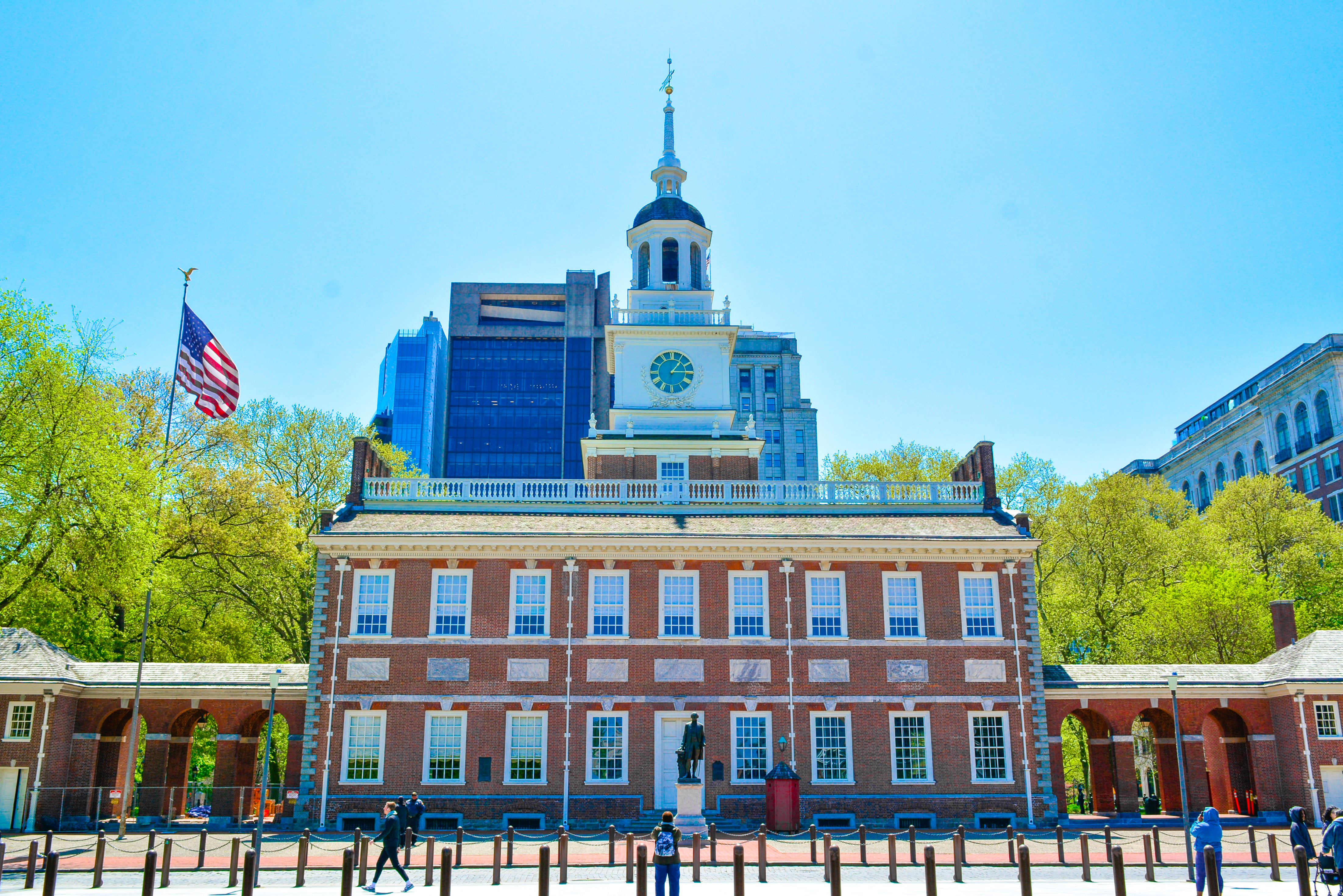This image shows the Chestnut Street side of Independence Hall with red brick facade, white window trim, and spire.
