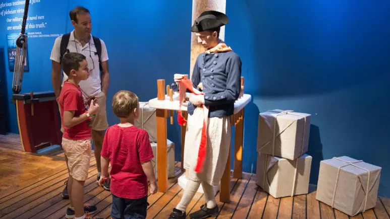Kids adding stitches to a flag