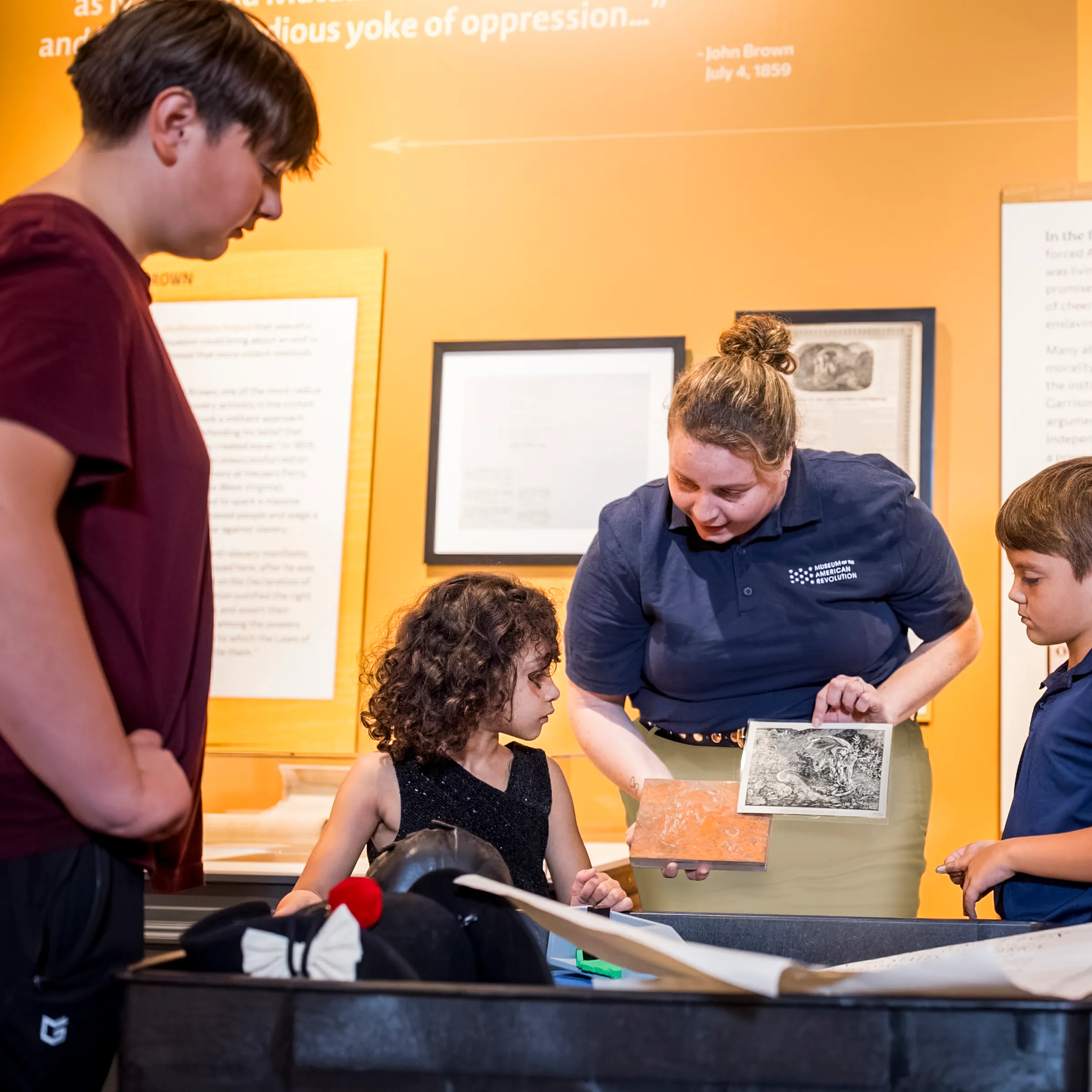 A Museum educator shows people objects on a discovery cart