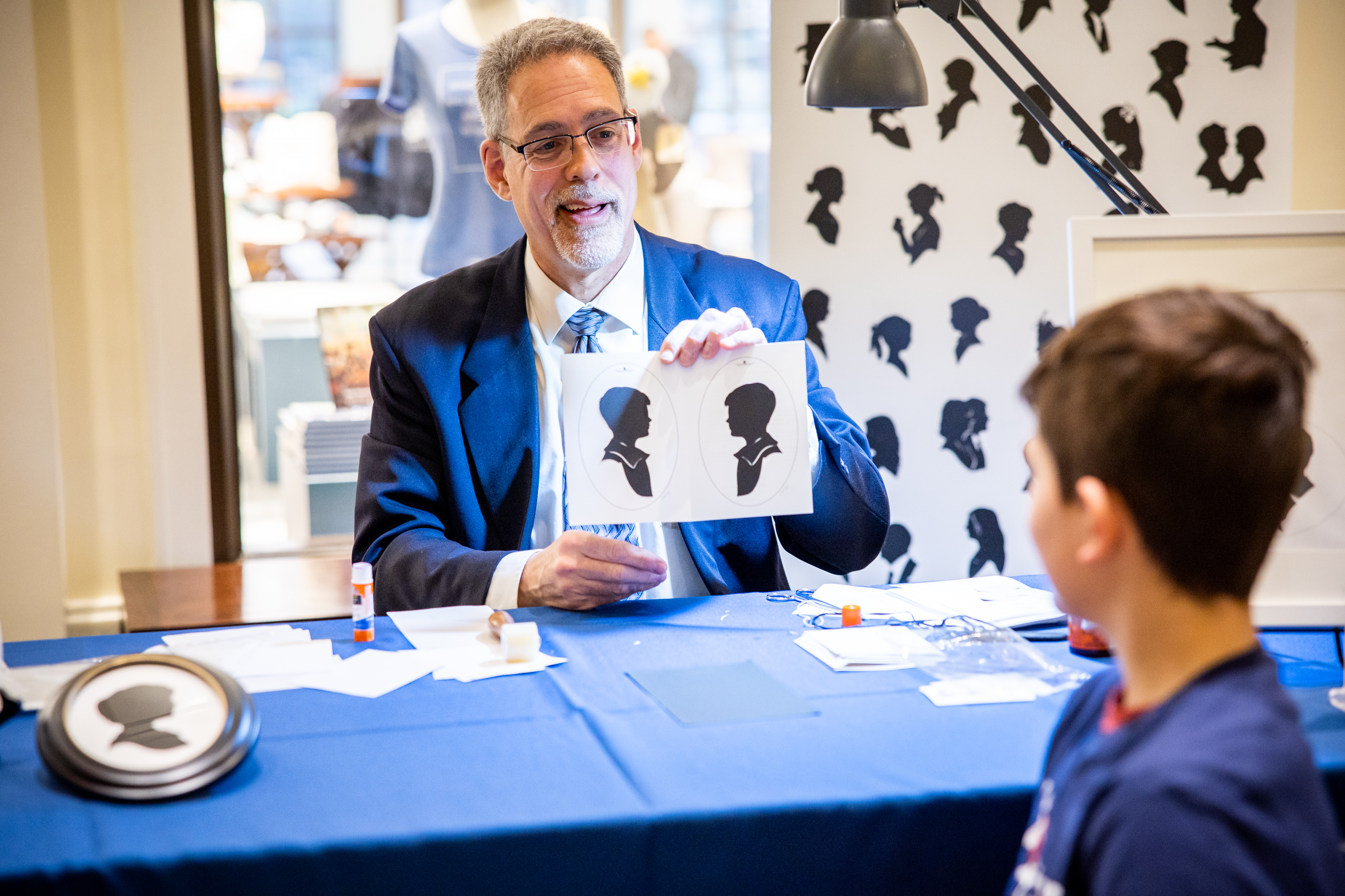 Silhouette artist T.J. Steussy shows a young visitor his silhouette during Winter Weekends at the Museum.