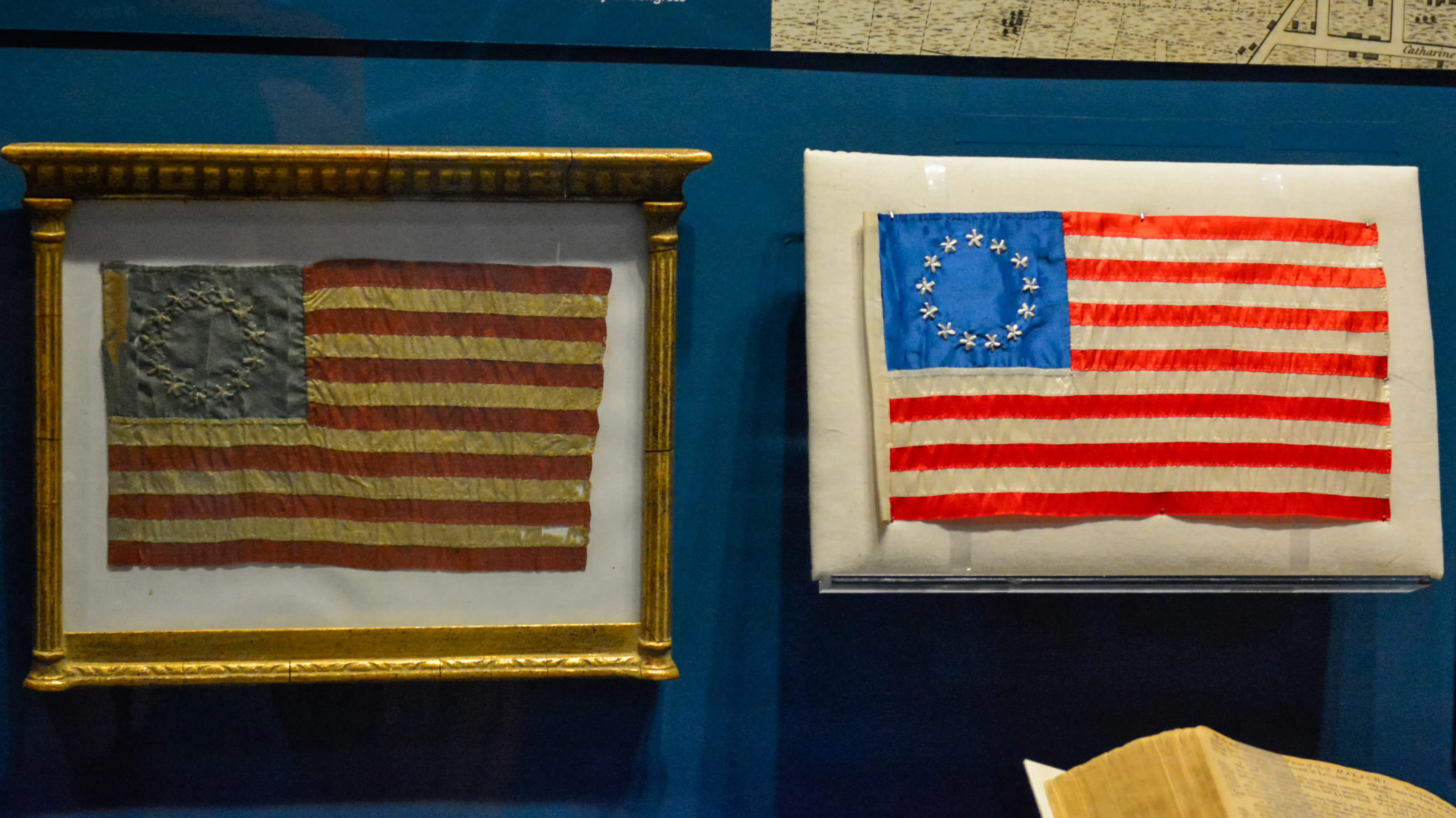 Two miniature Betsy Ross style 13-star flags made by her granddaughter and great-granddaughter.
