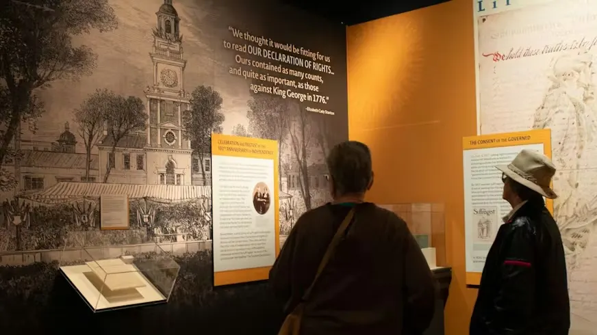 Women look at objects in The Declaration's Journey