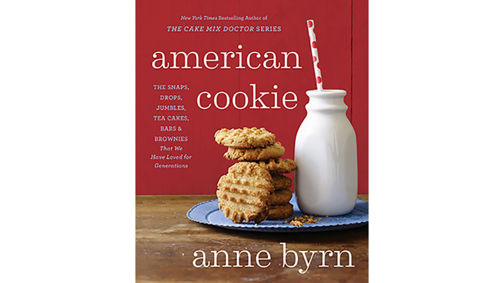 This image depicts the book cover of American Cookie by Anne Byrn. There is a stack of peanut butter cookies and a glass of milk with straw. The milk and cookies are on a blue plate on a wooden table with a red background.
