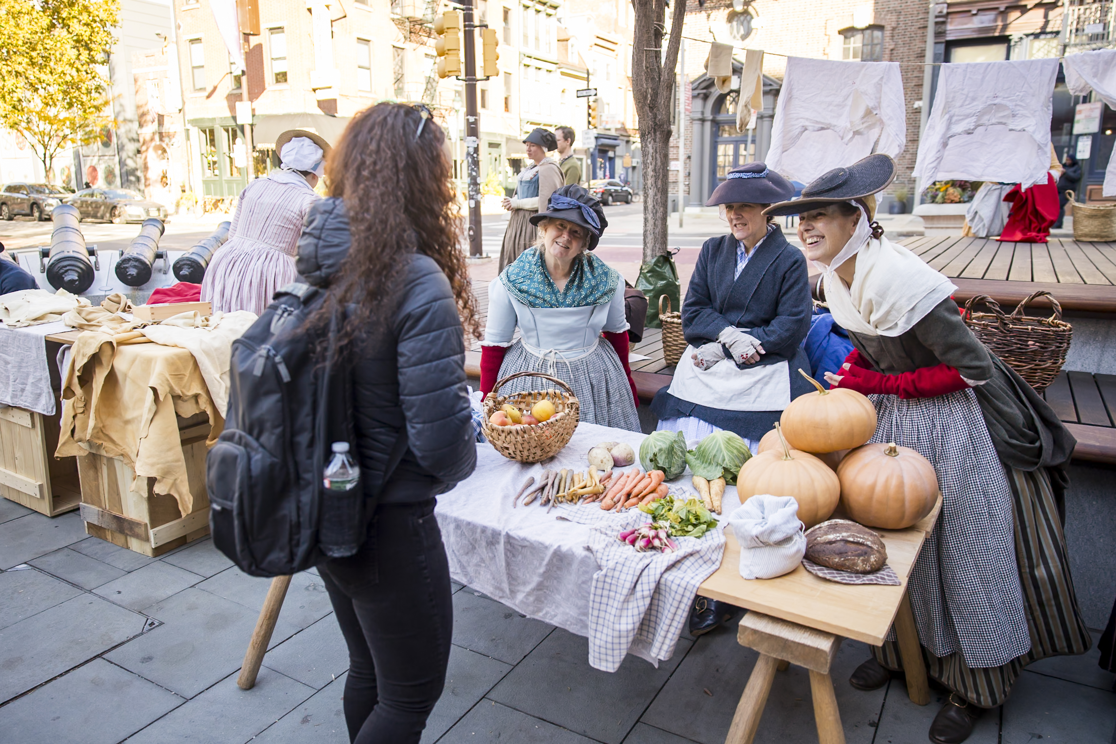 Costumed interpreters speak with a visitor