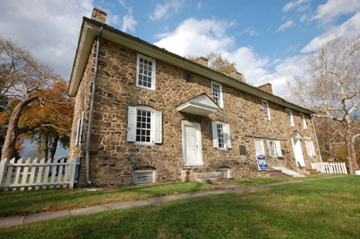 This image shows the stone house with white shutters that is the Thompson-Neely House and Farmstead.