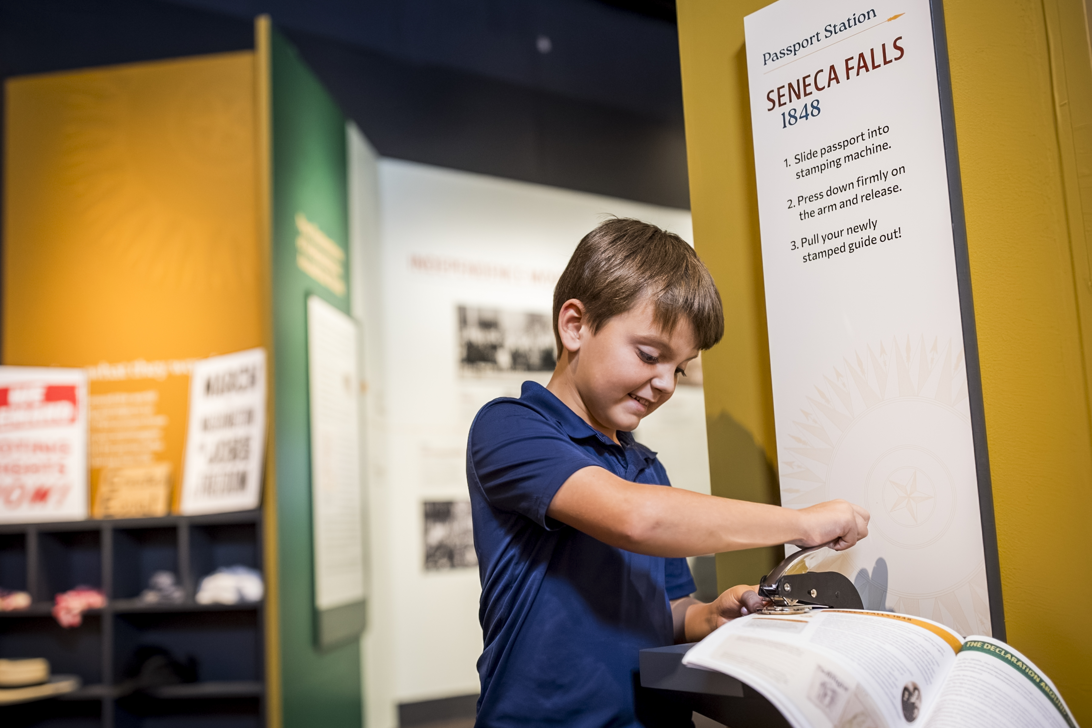A child stamps a family guide in "The Declaration's Journey" exhibition