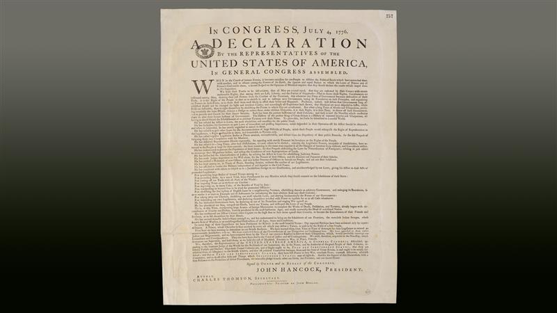A printing of the Declaration of Independence on a gradient gray-to-black background.