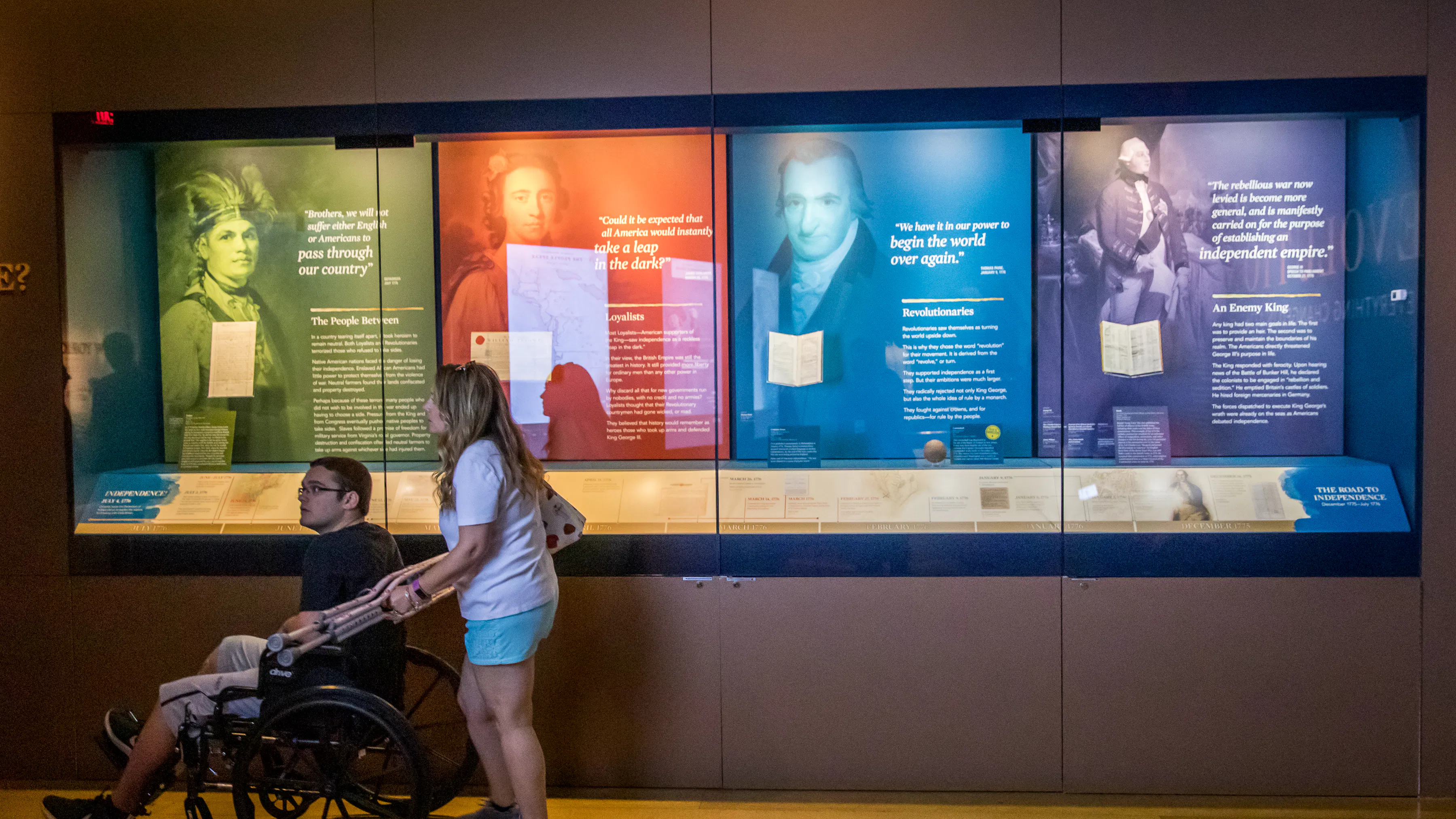 Guests in front of a case with four distinct colored sections