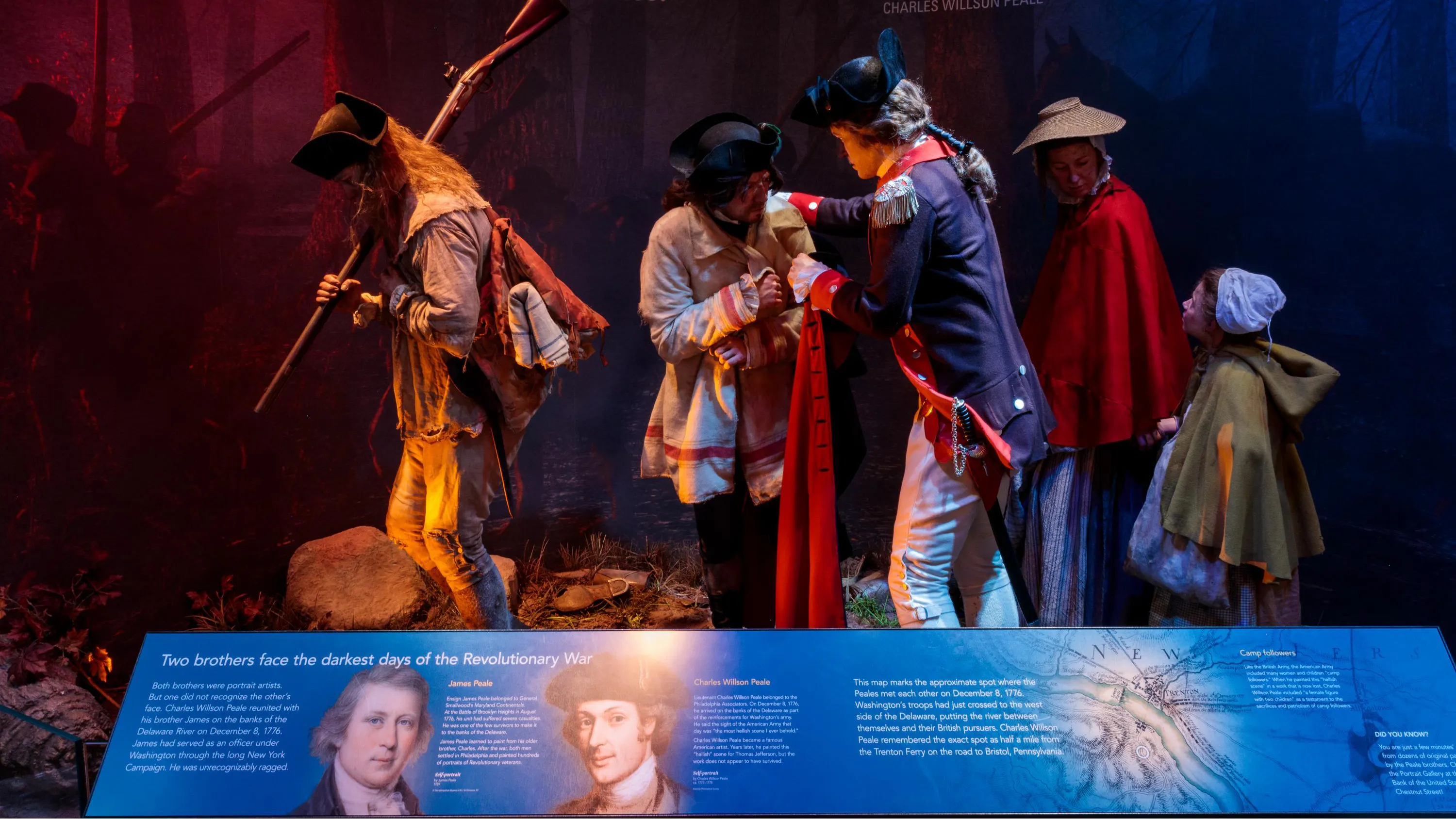 Lifelike figures of three men, a woman, and a child, behind a placard with text on it