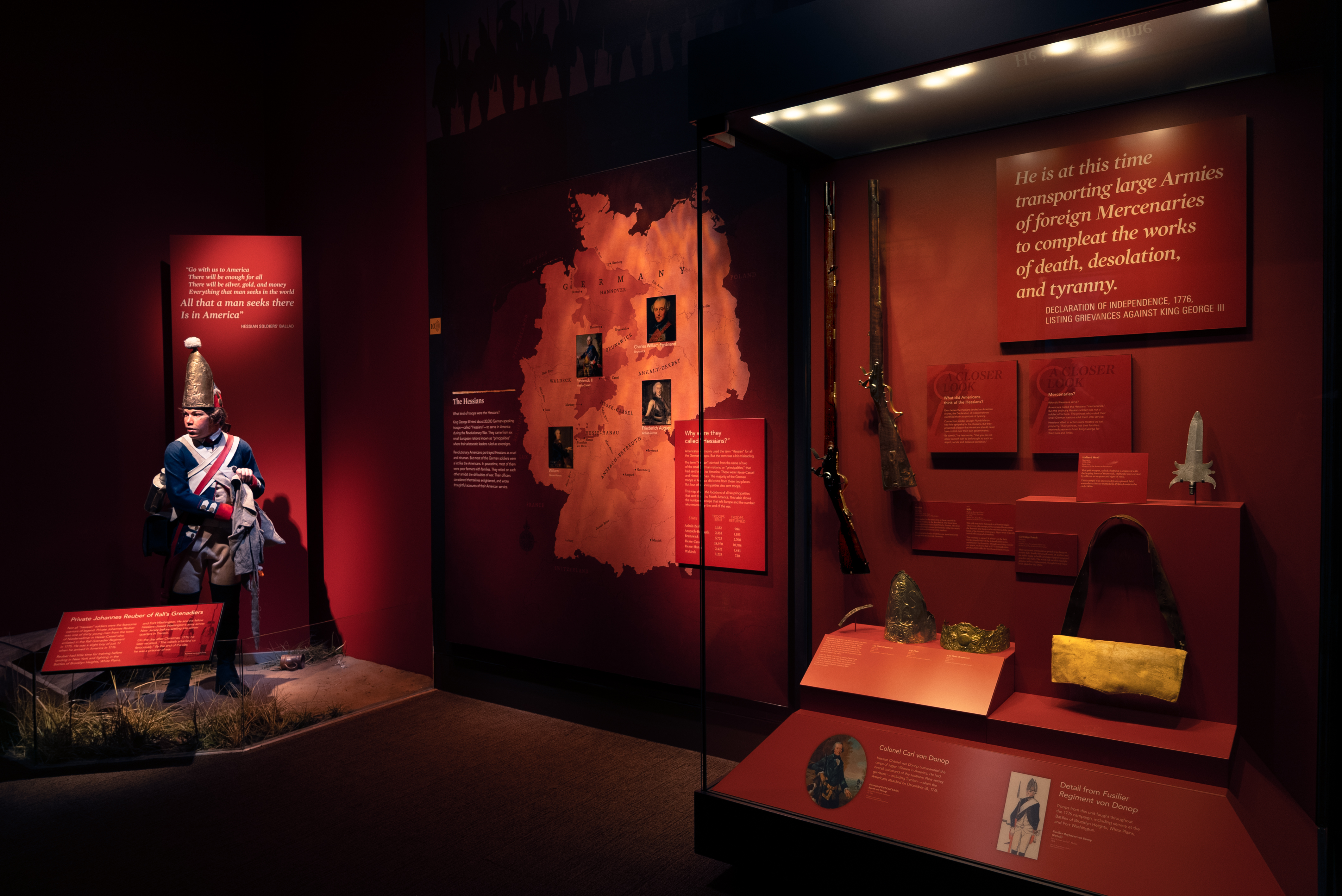 A tableay figure of a Hessian soldier in a museum setting next to a display case.