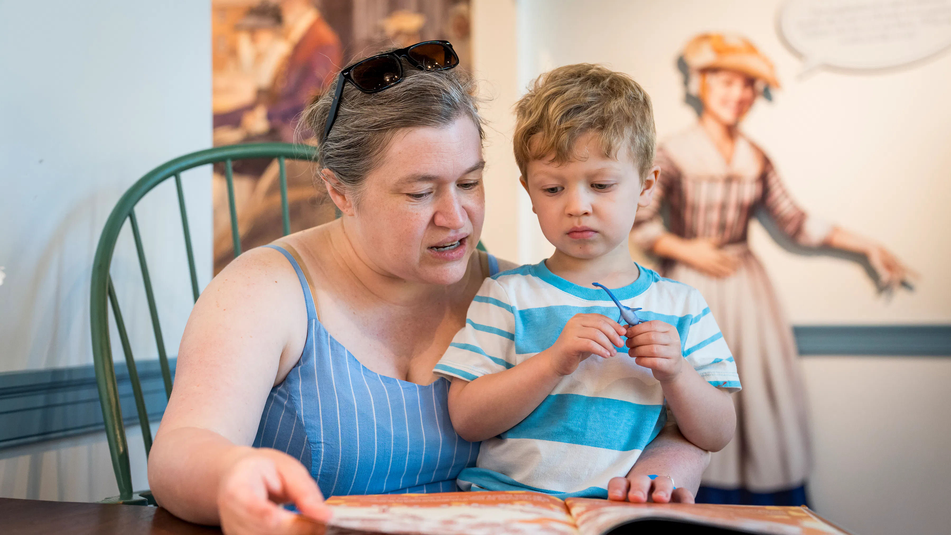A woman and a child read a book in Revolution Place