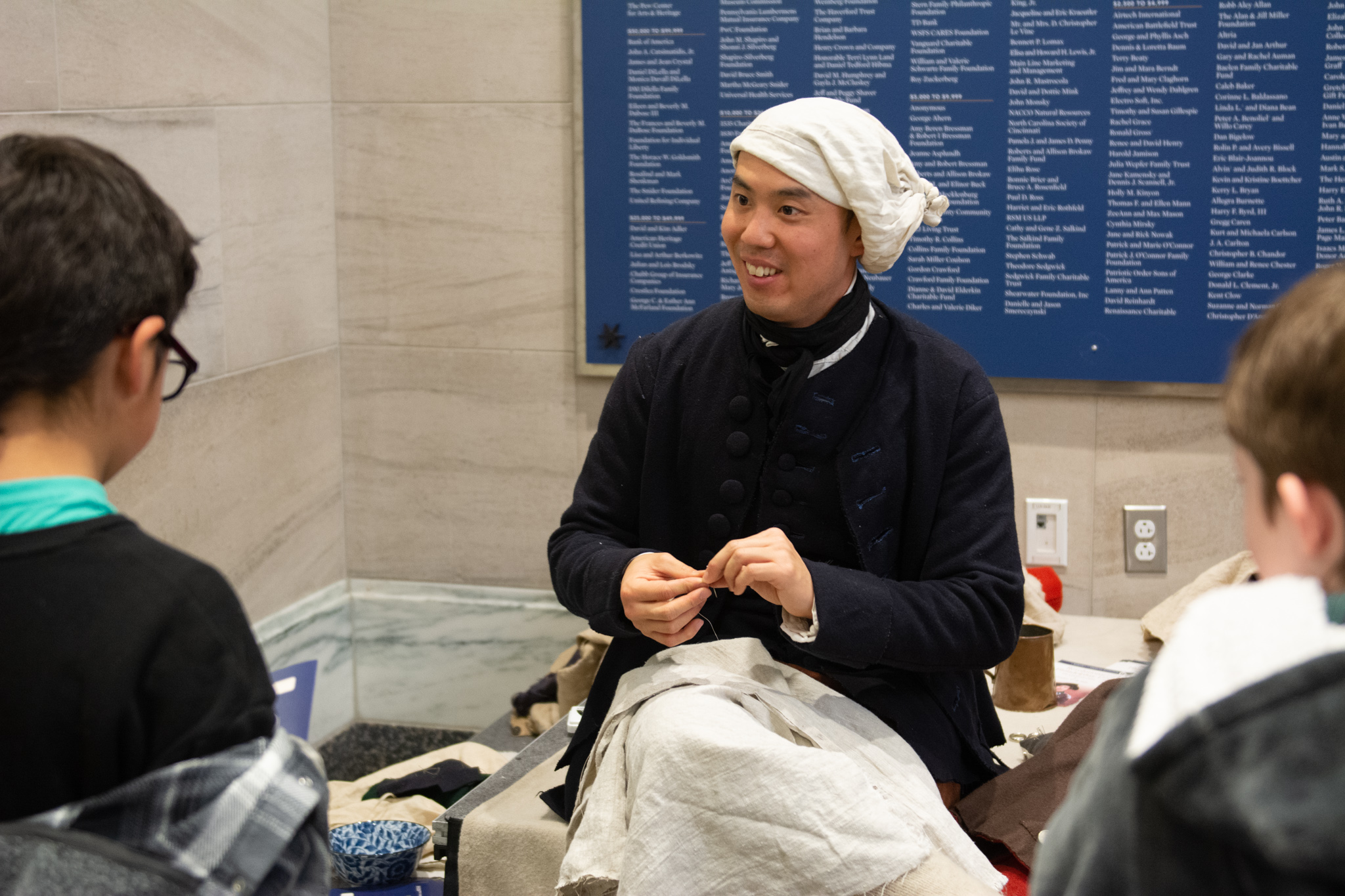 A costumed interpreter speaks with children