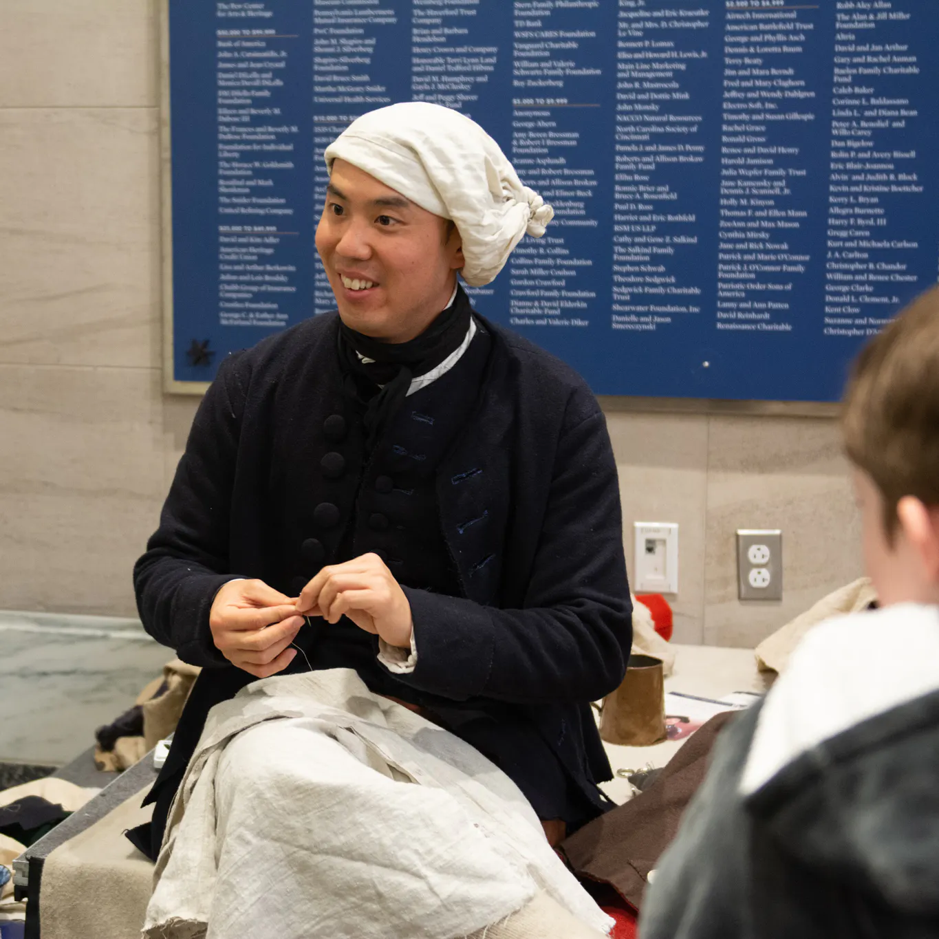 A costumed interpreter speaks with children