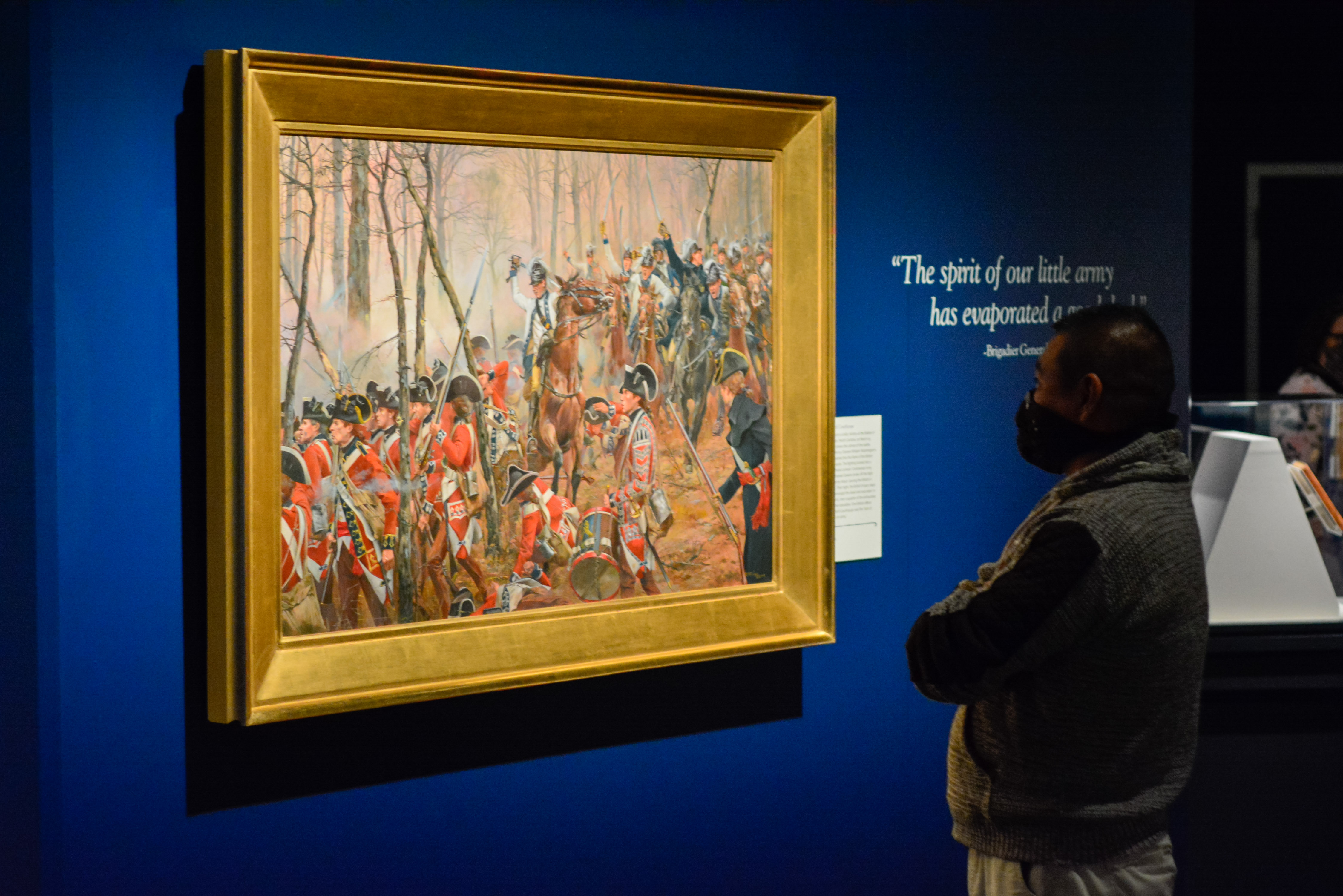 A Museum staff member views a painting in the Liberty exhibit