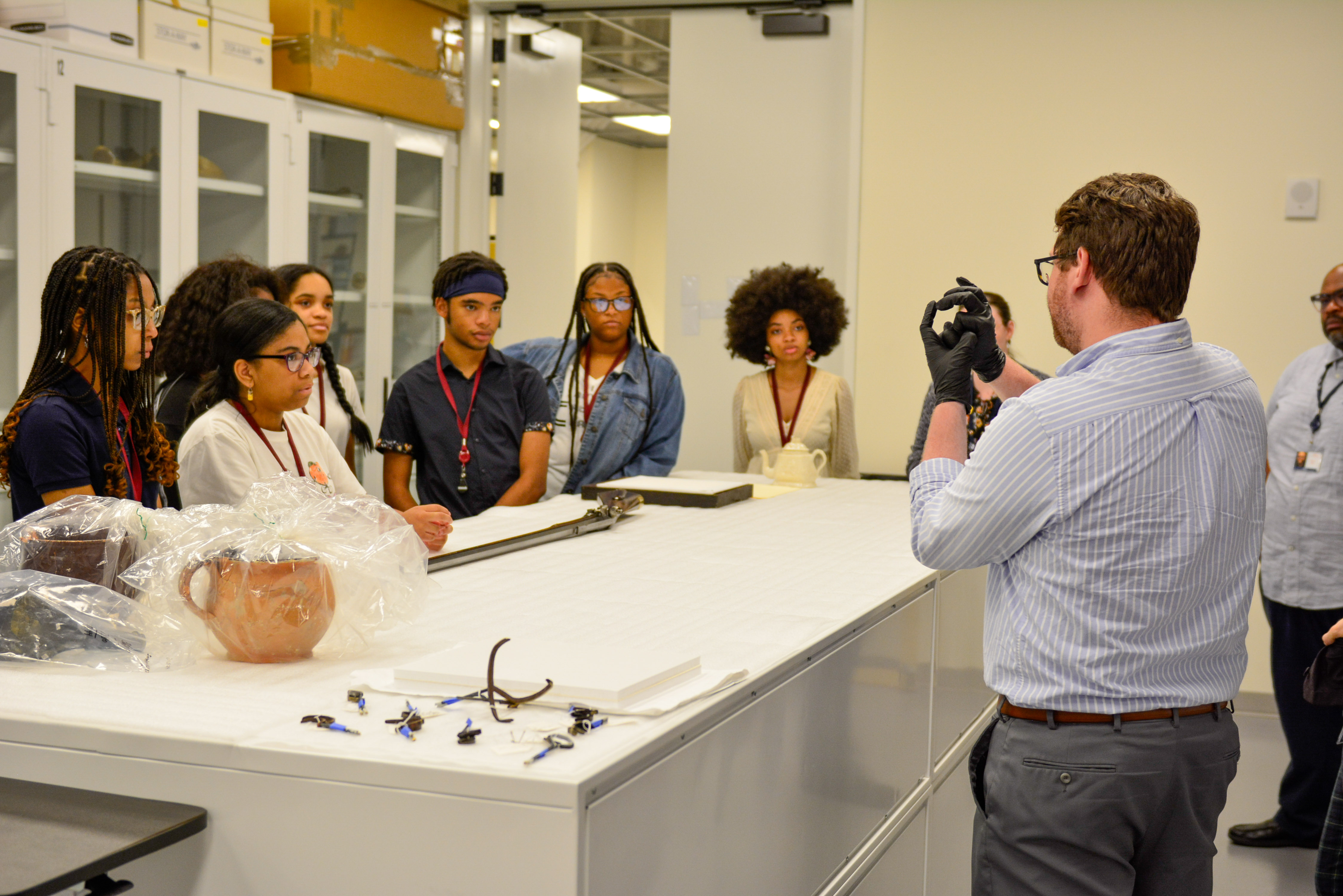 The 2023 Living History Youth Summer Institute Students tour the collections storage area at the Museum with the collections and curatorial team.