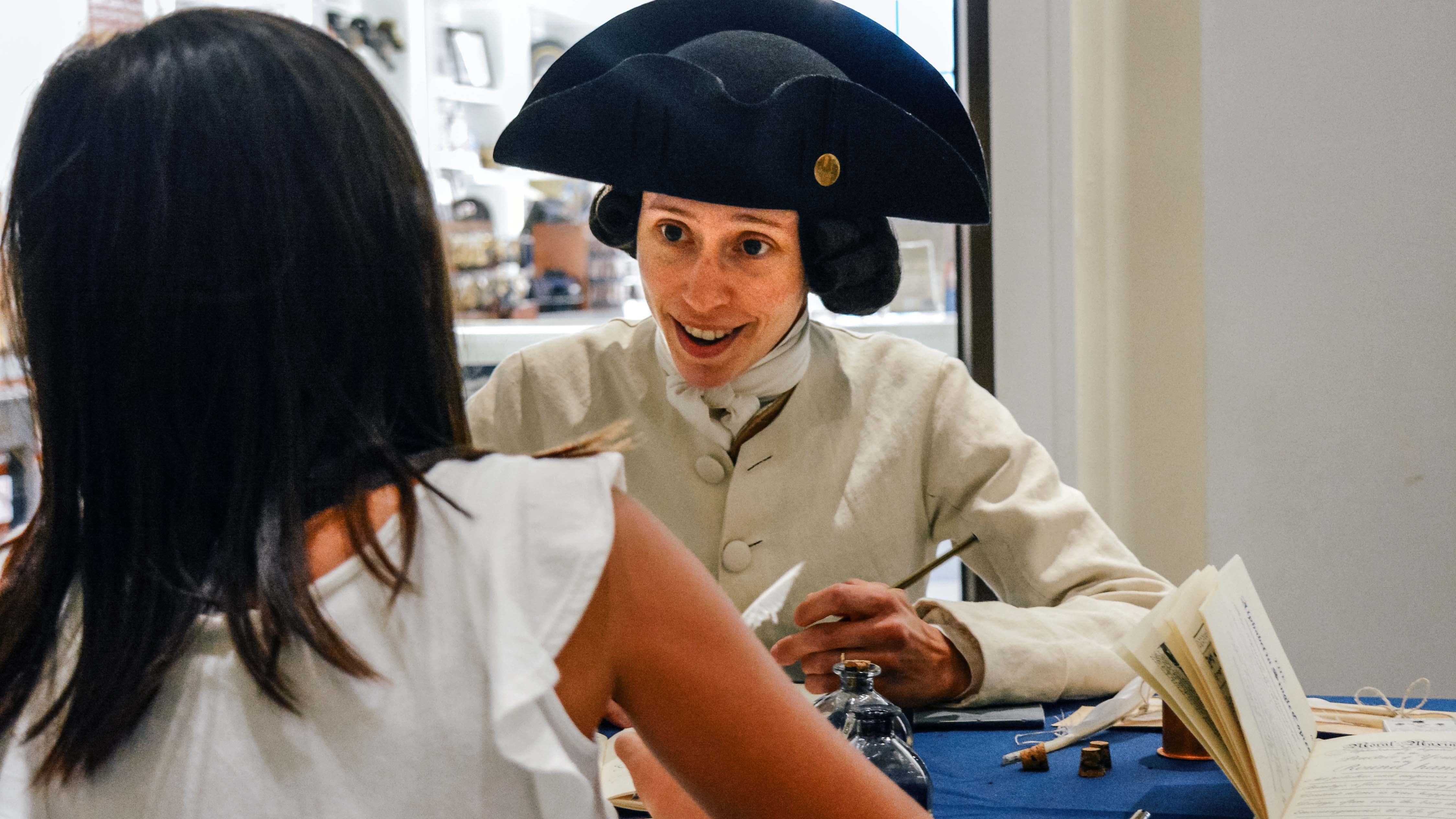 Ben Bartgis demonstrates historical writing techniques to a young History After Hours attendee