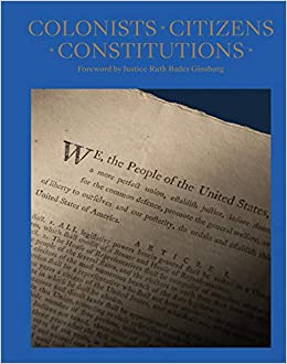 The image depicts Colonists Citizens Constitutions book cover by James Hrdlicka. It is a blue cover with a photo of the first few lines of the constitution. “We, the people of the United States,” is a visible.