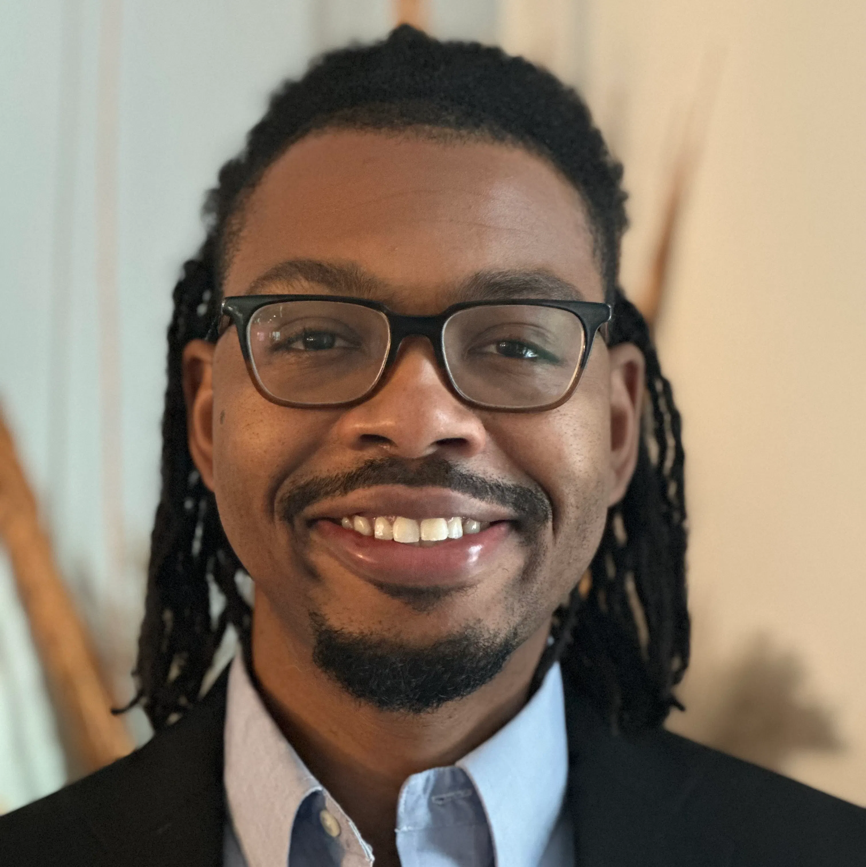 Portrait of Jason M Coles with glasses, a goatee, and shoulder length hair