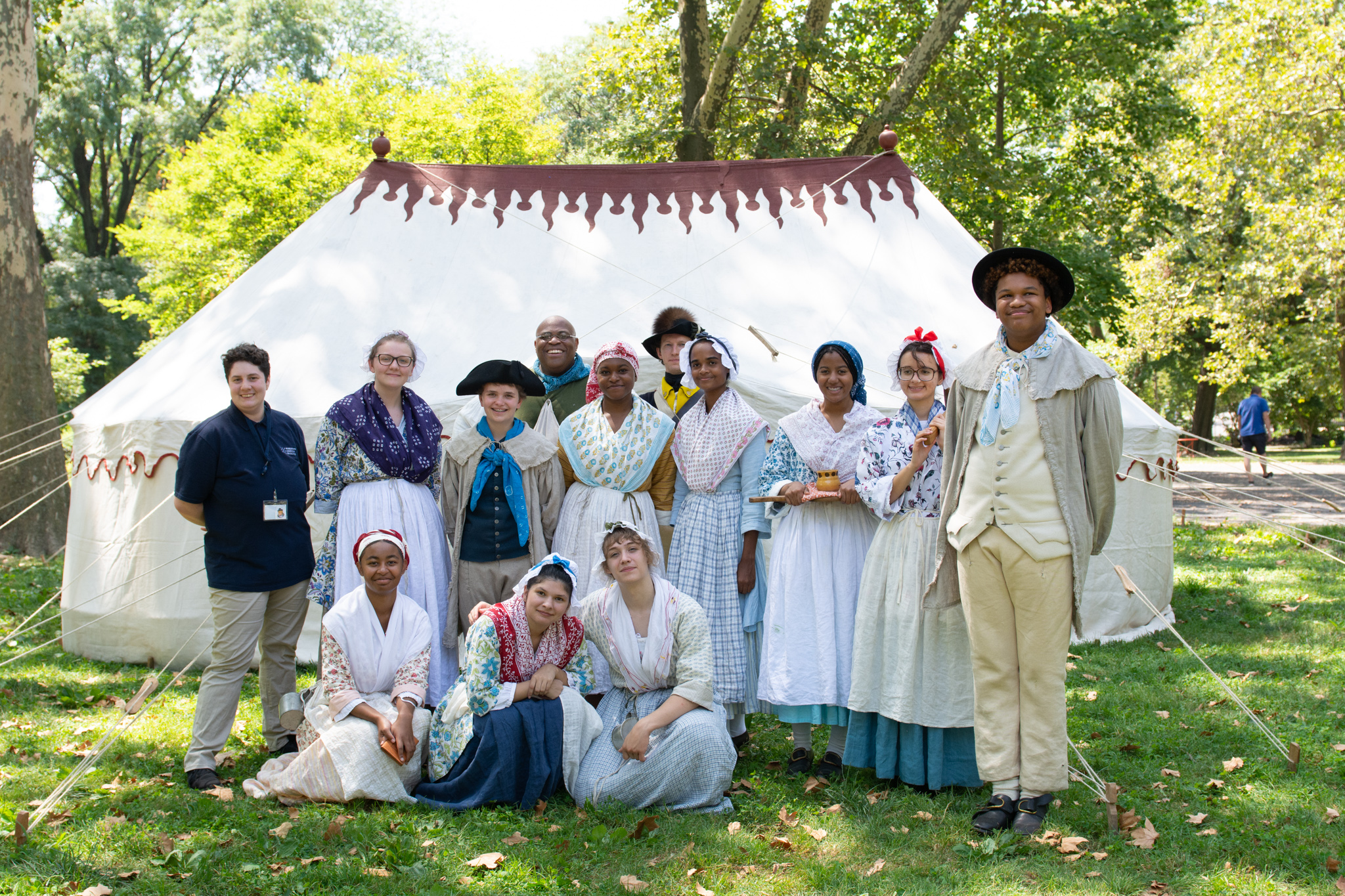 A group of Living History Youth Summer Institute students pose in front of the tent