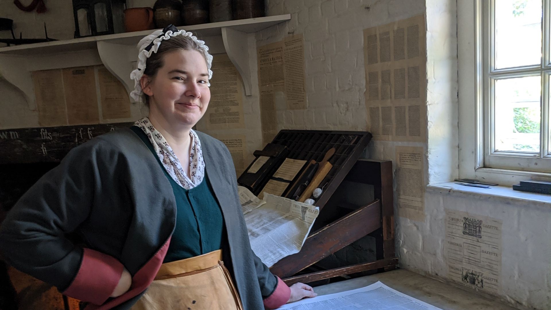 A costumed interpreter standing next to a window