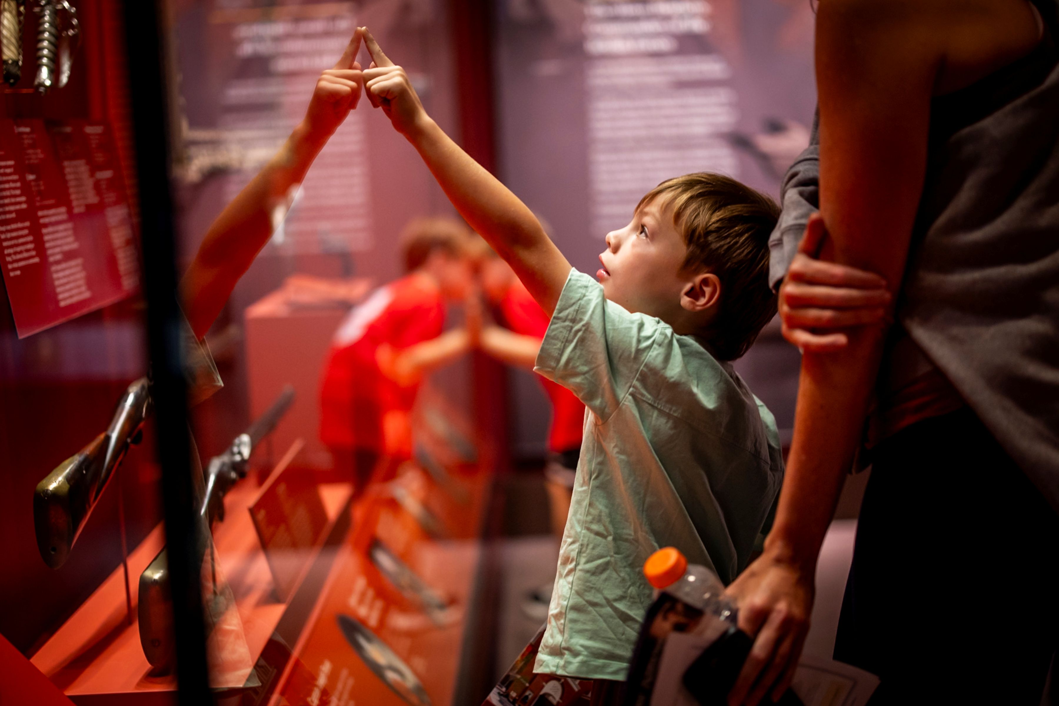 A child pointing at the wall in an exhibit