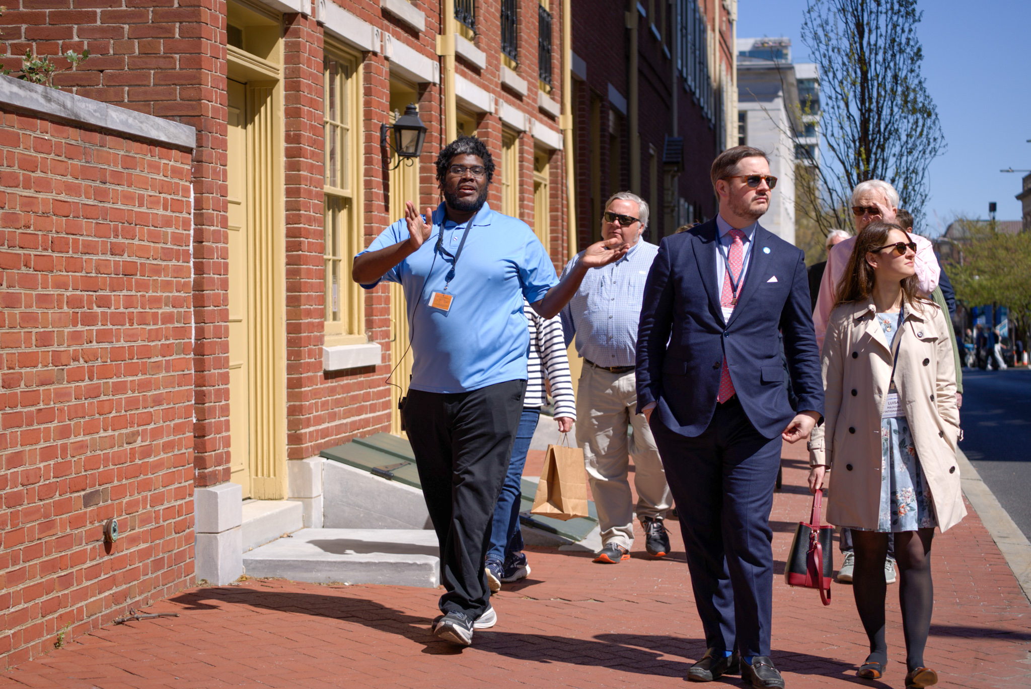 A man in a light blue shirt leads a tour group in Old City