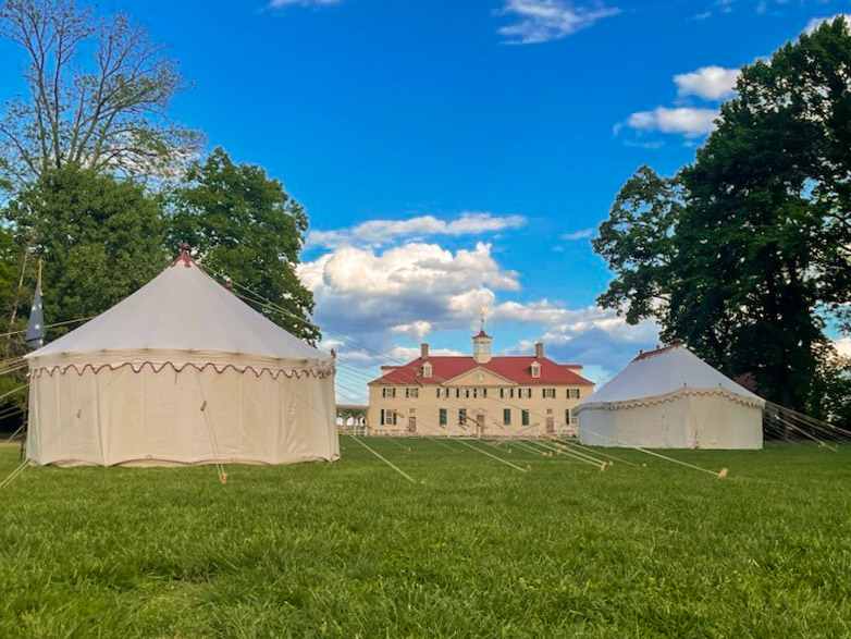 The Museum's replica George Washington headquarters tents set up on Mount Vernon's lawn with the mansion in the background.