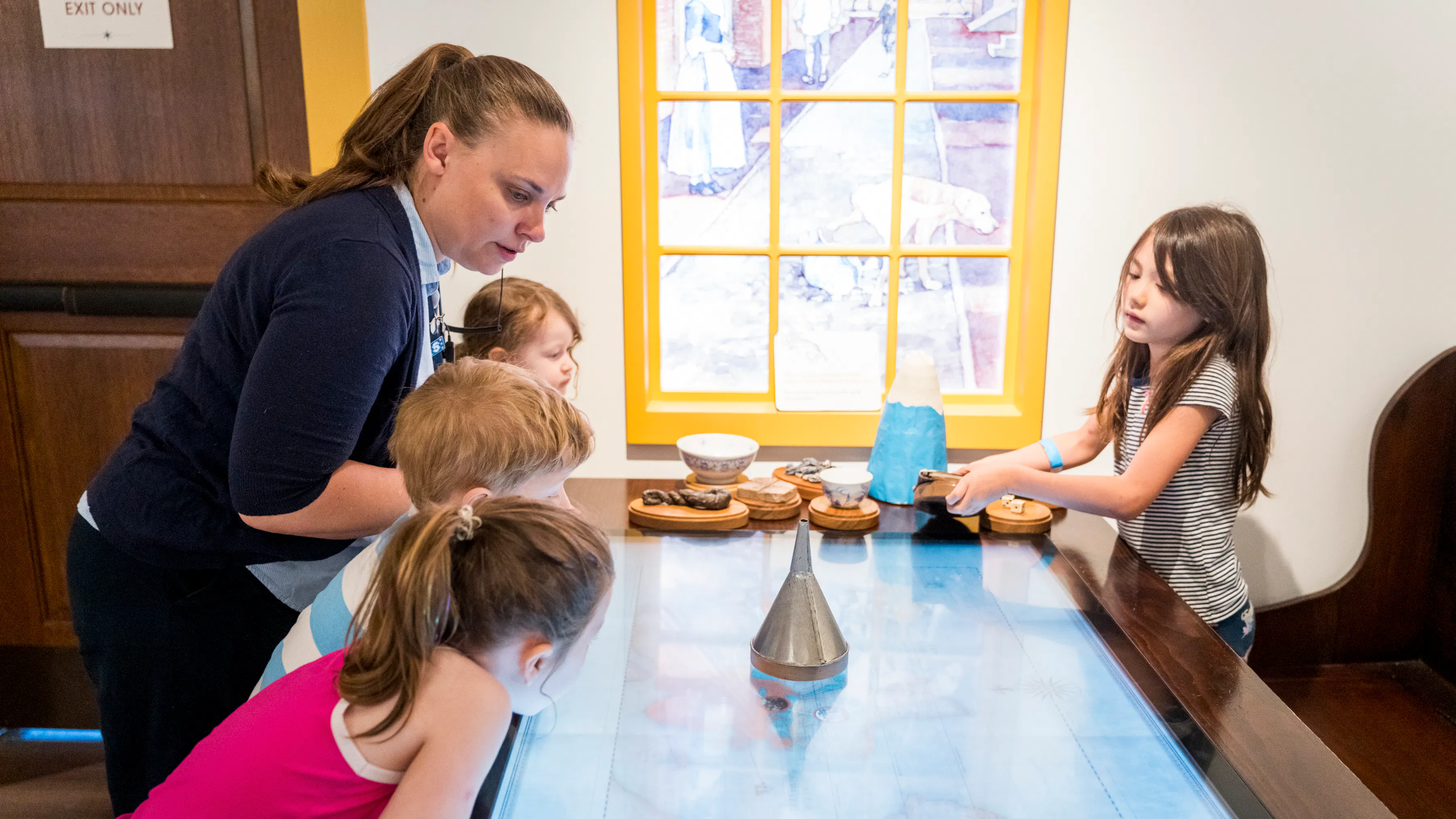 Children and a Museum educator at the map table in in Revolution Place
