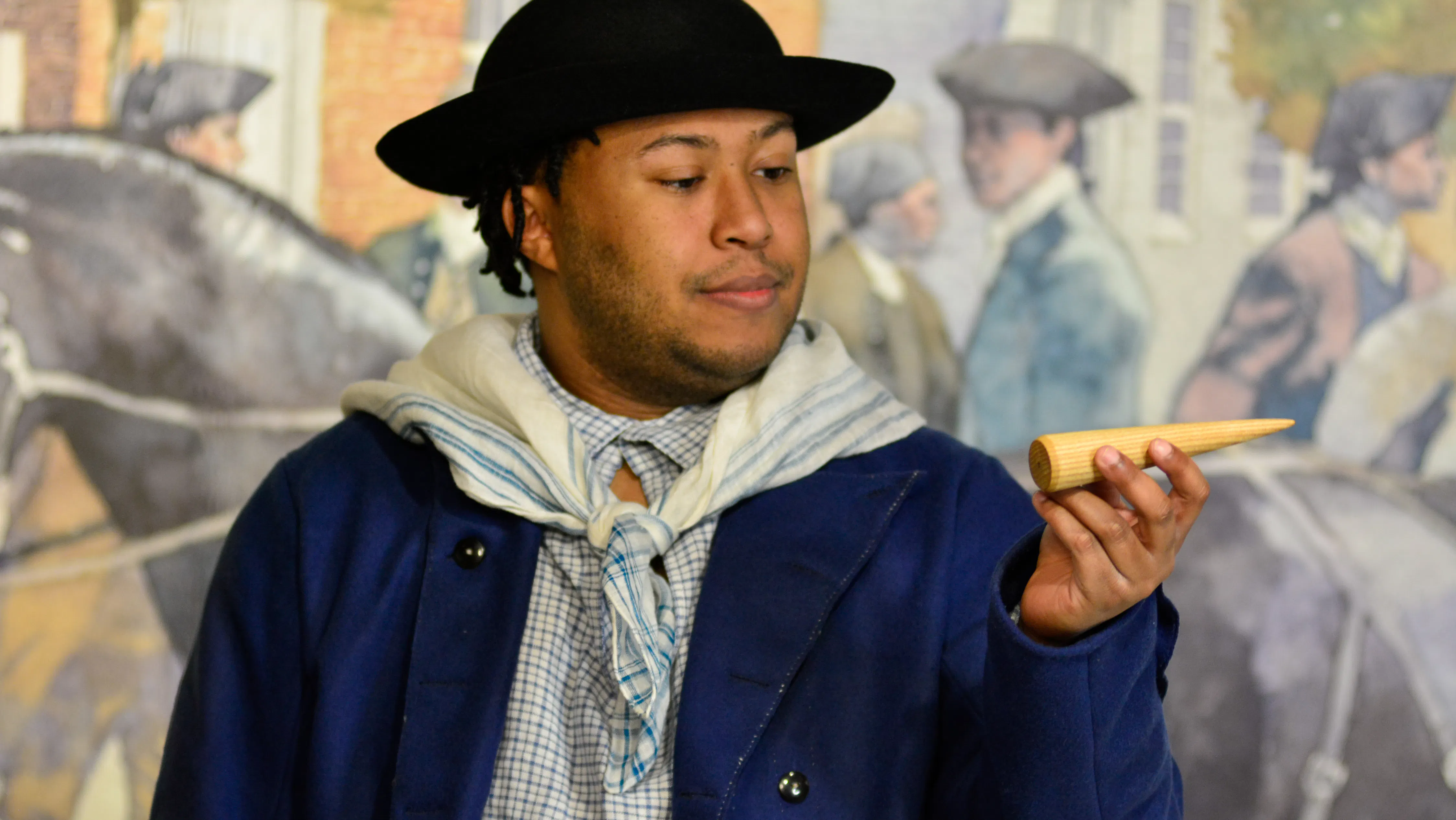 Actor Nathan Alford-Tate depicts a sailor in a blue coat holding a sailmaking fid in our Meet James Forten first-person theatrical performance.