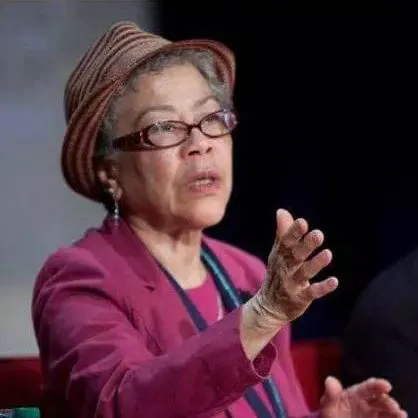 Historian Rosalyn Terborg Penn of Morgan State speaks to an audience while wearing glasses, a fuchsia shirt, and a hat.