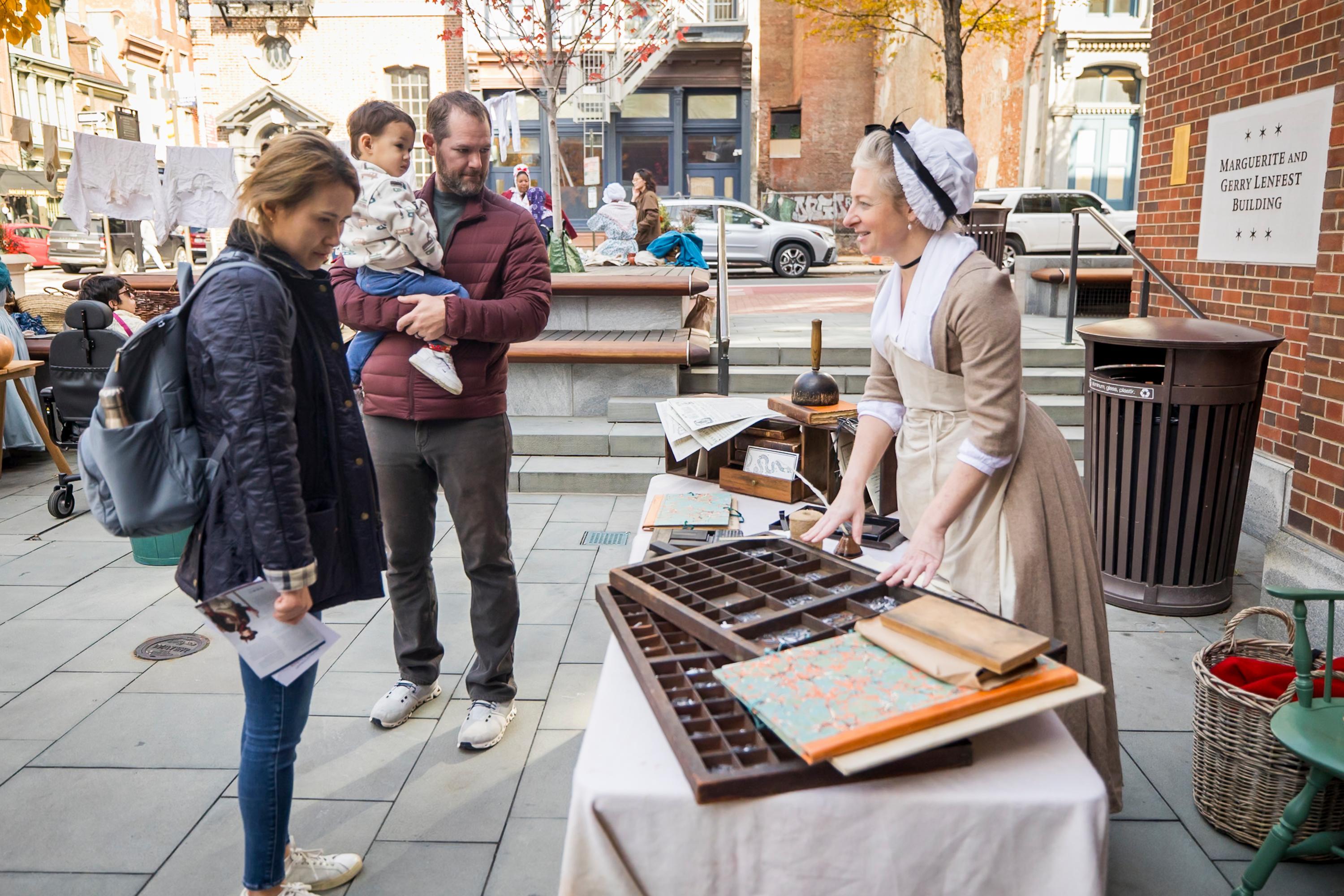 A costumed interpreter talks with guests