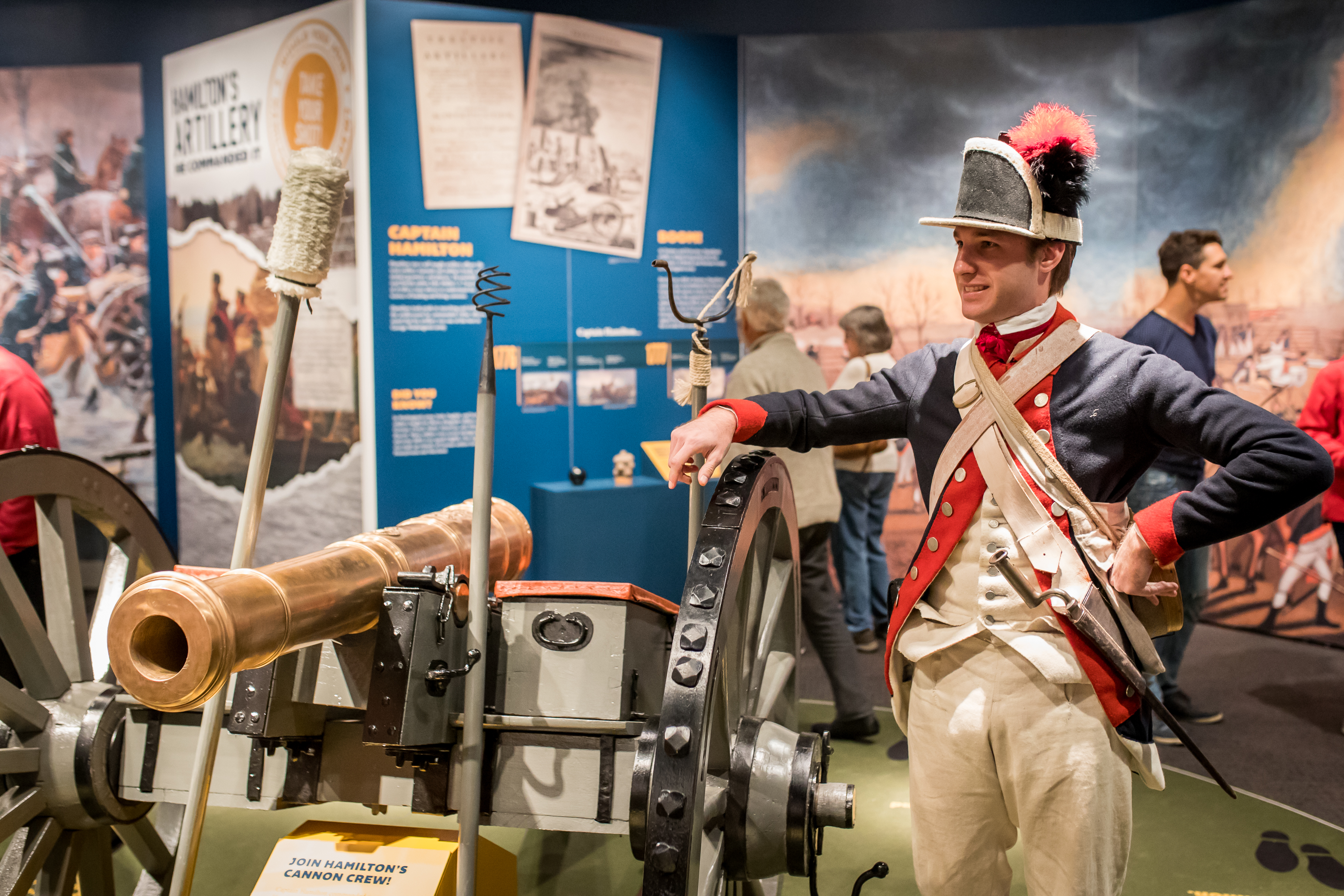 A male costumed Museum educator gives a demonstration about a cannon as part of the Hamilton Was Here exhibit.