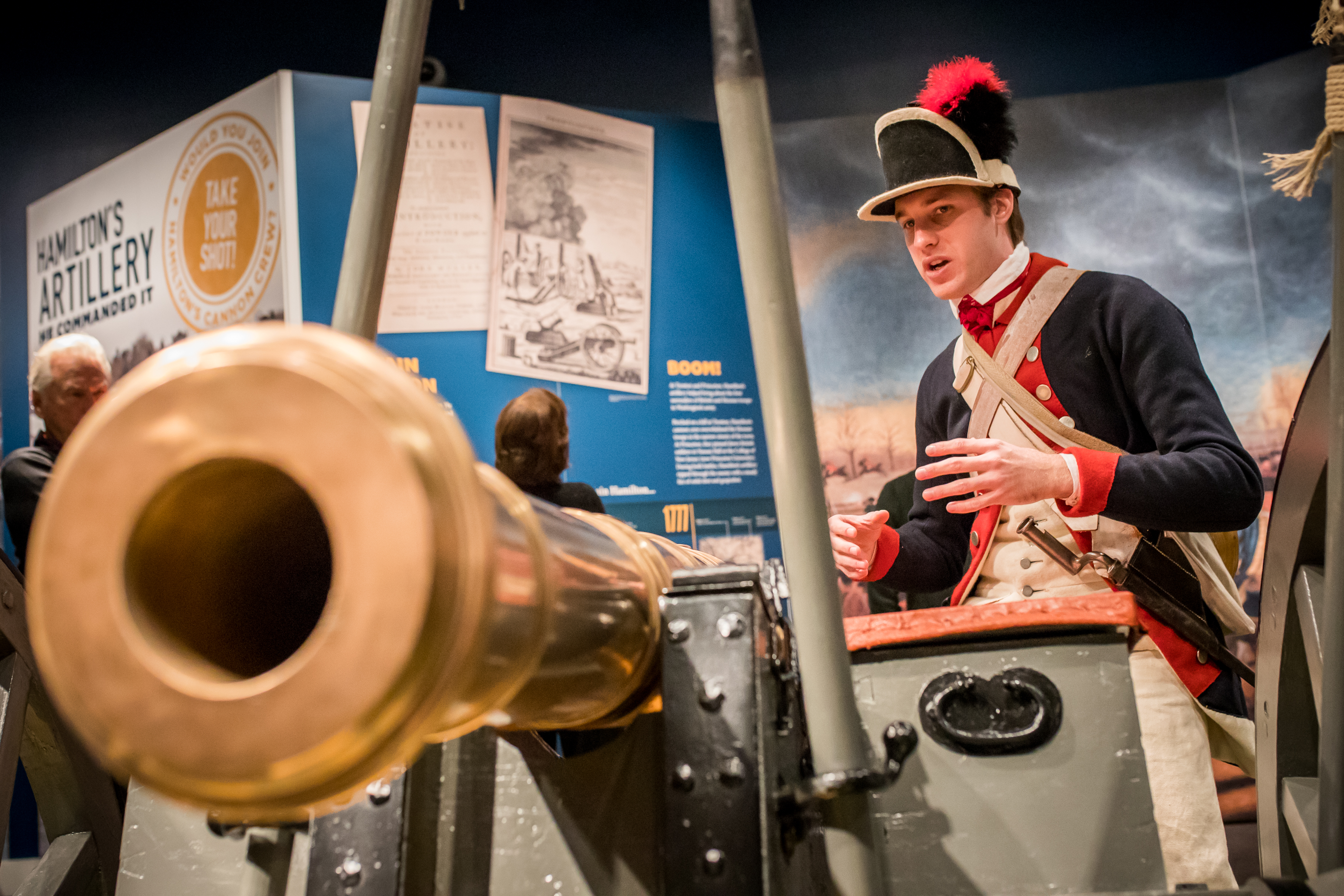 A male costumed Museum educator gives a demonstration about a cannon as part of the Hamilton Was Here exhibit.