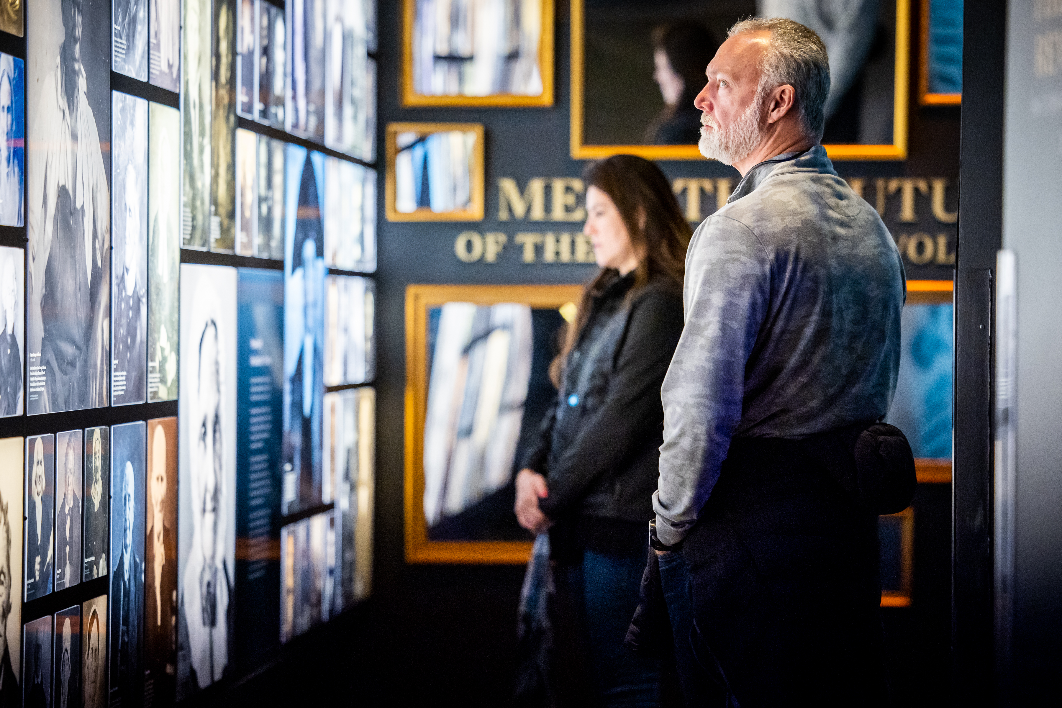 A visitor views the photographs on the Revolutionary Generation wall in the core exhibition.