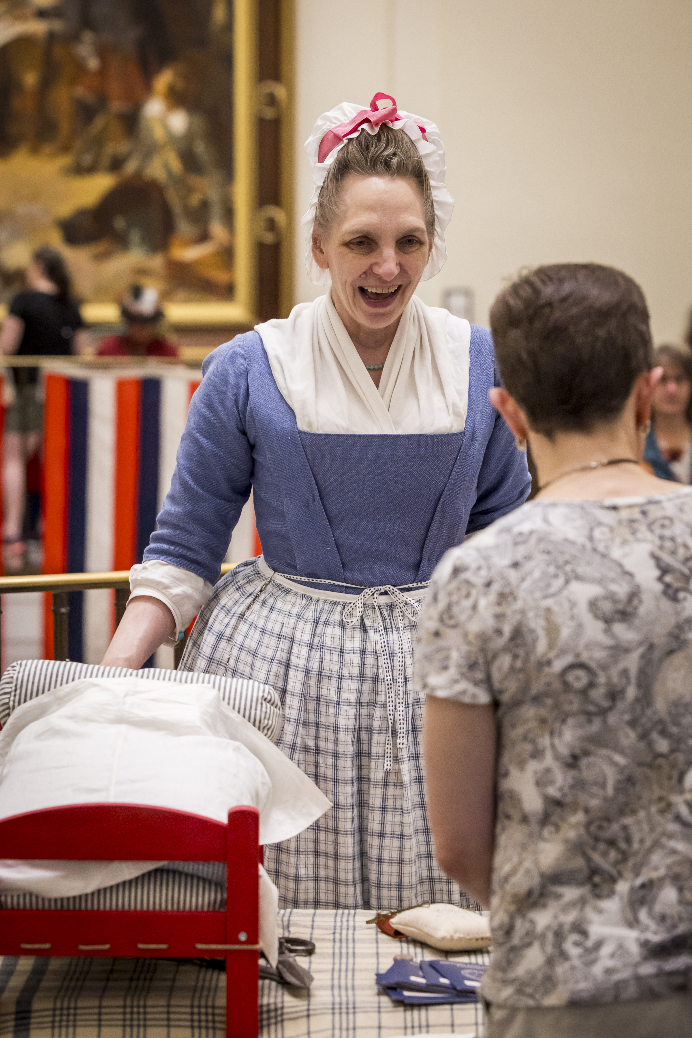 A costumed interpreter talks to a guest