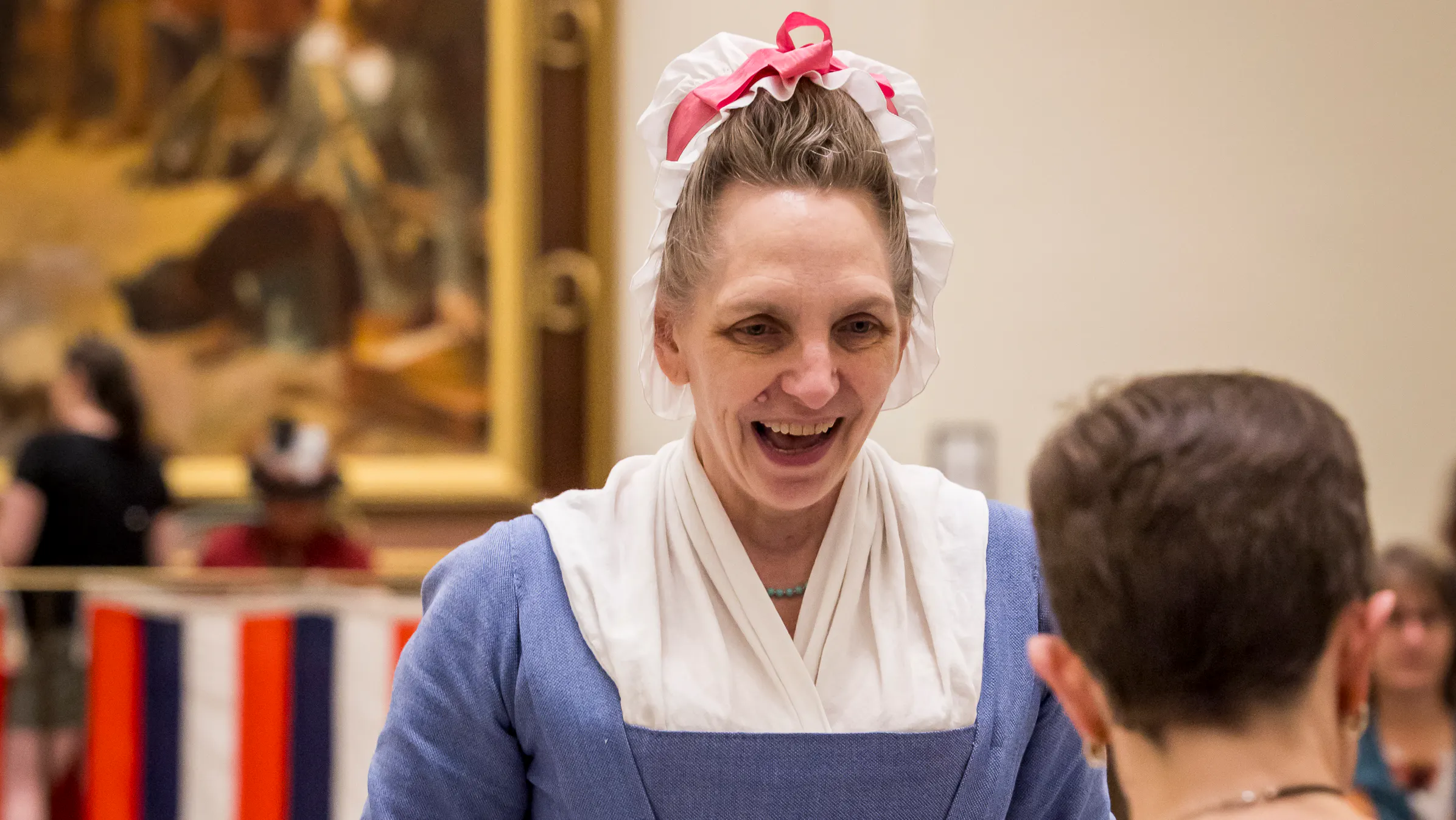 A costumed interpreter talks to a guest