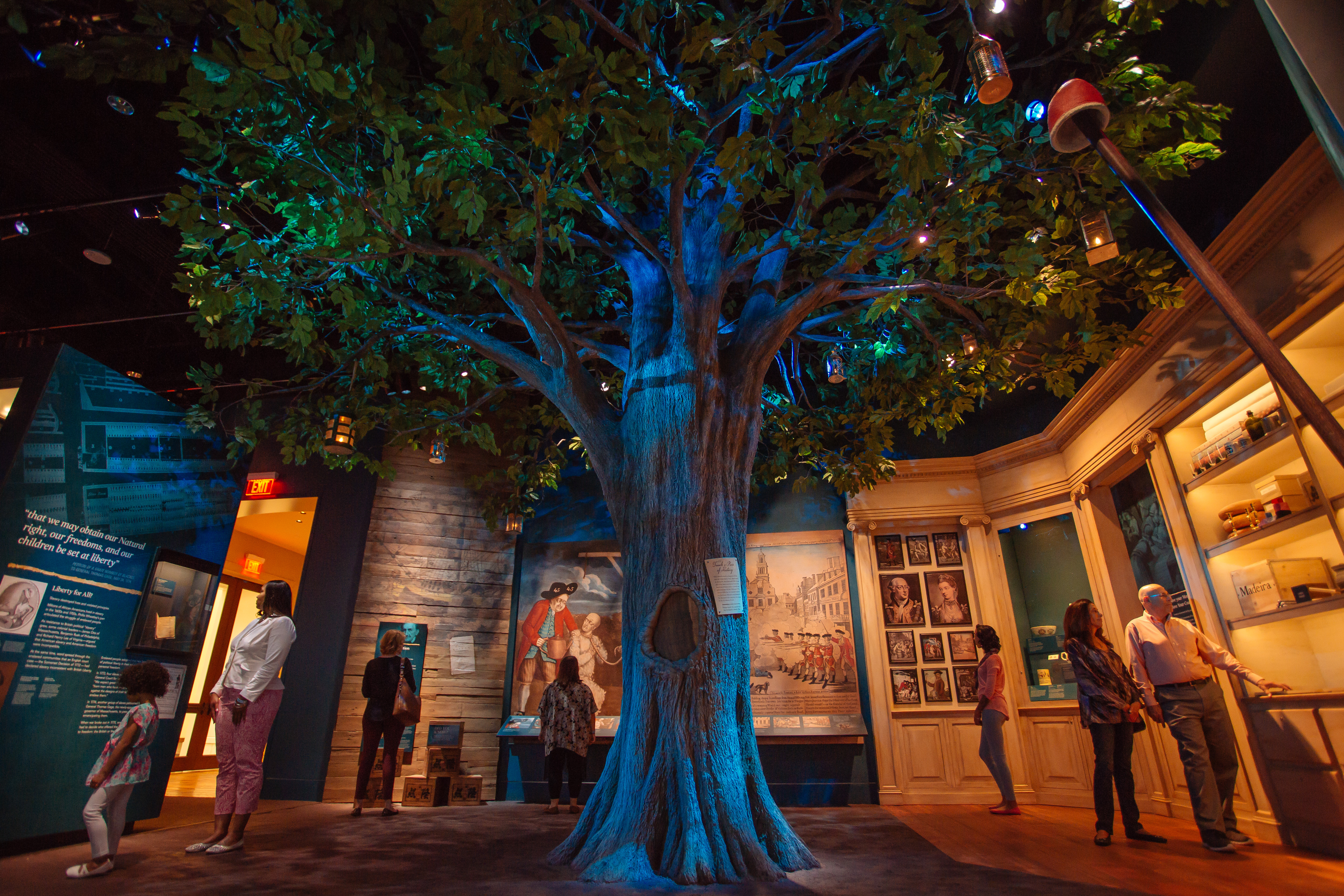 Visitors of the Museum of the American Revolution in the Liberty Tree gallery which features a Liberty Tree