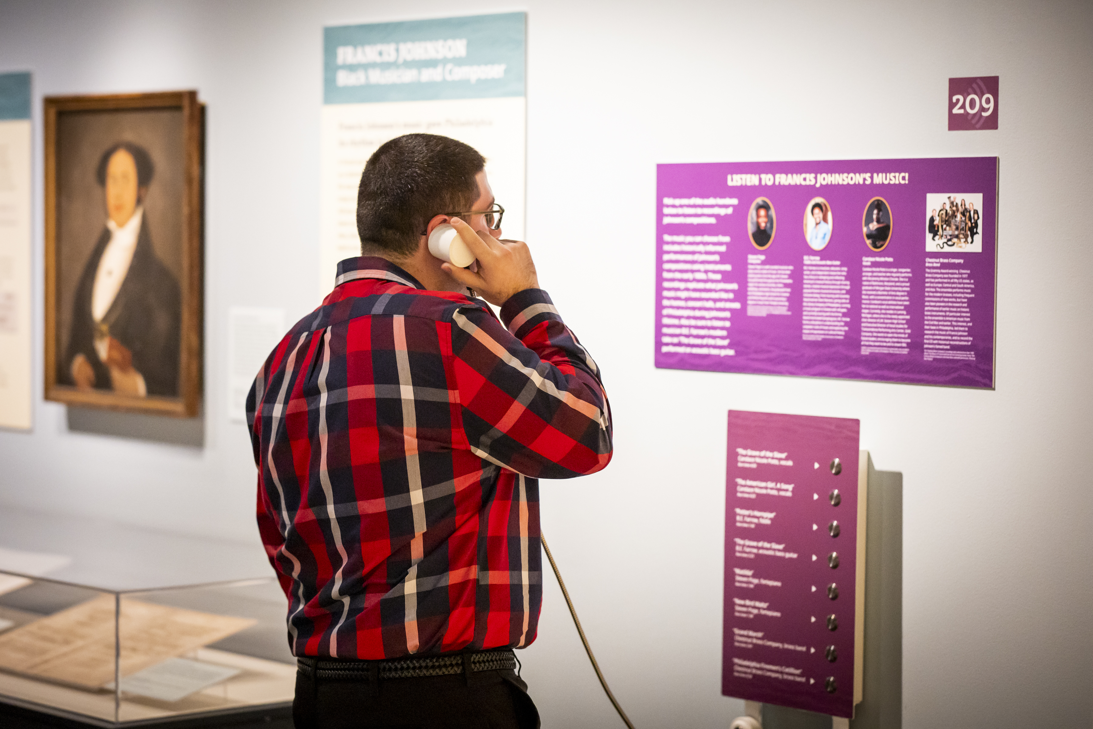 A visitor listens to the music of Black composer Francis Johnson at a listening station in the Museum's Black Founders exhibit.