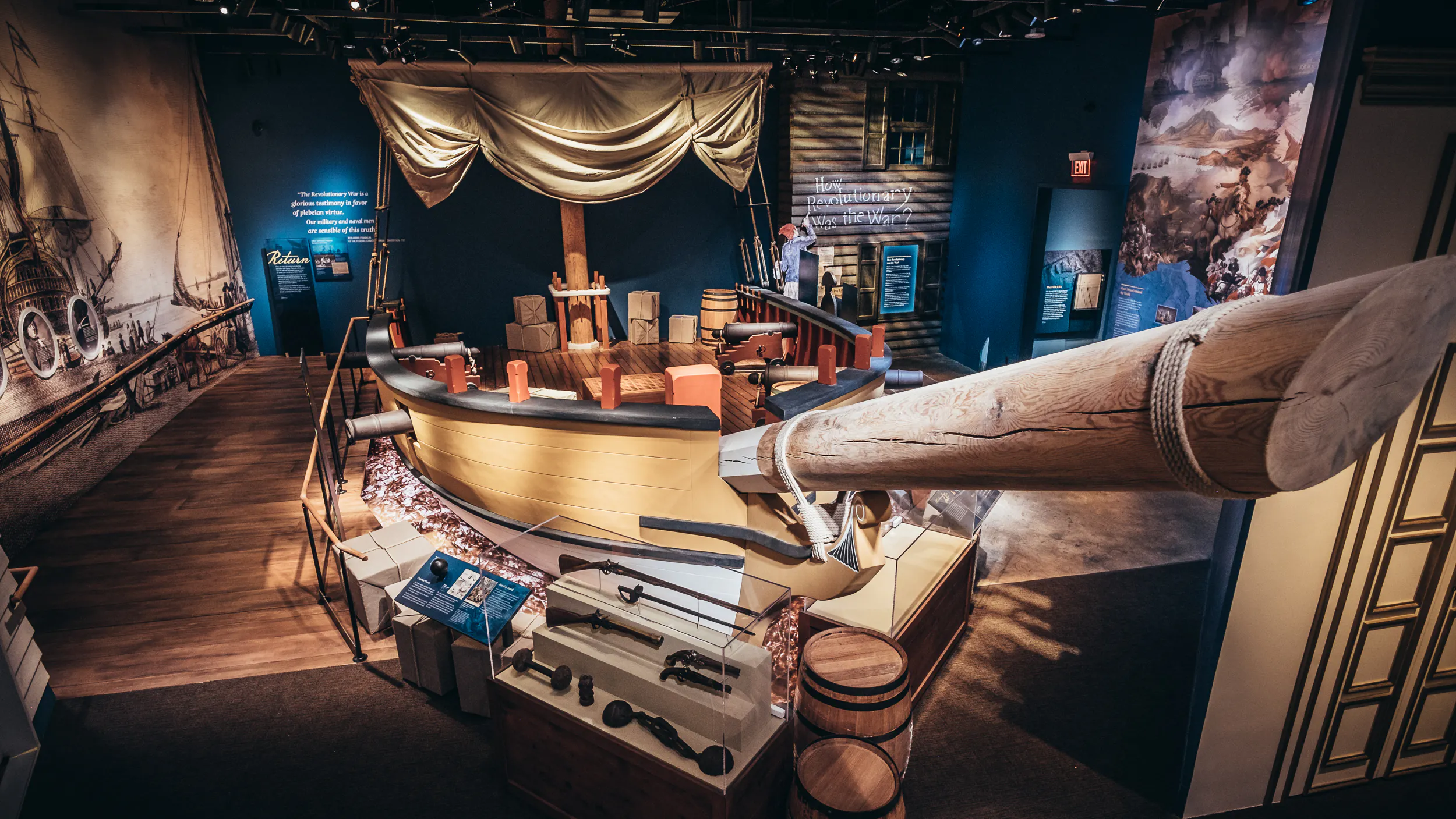 A high up view of the War at Sea gallery in the Museum of the American Revolution featuring a sloop