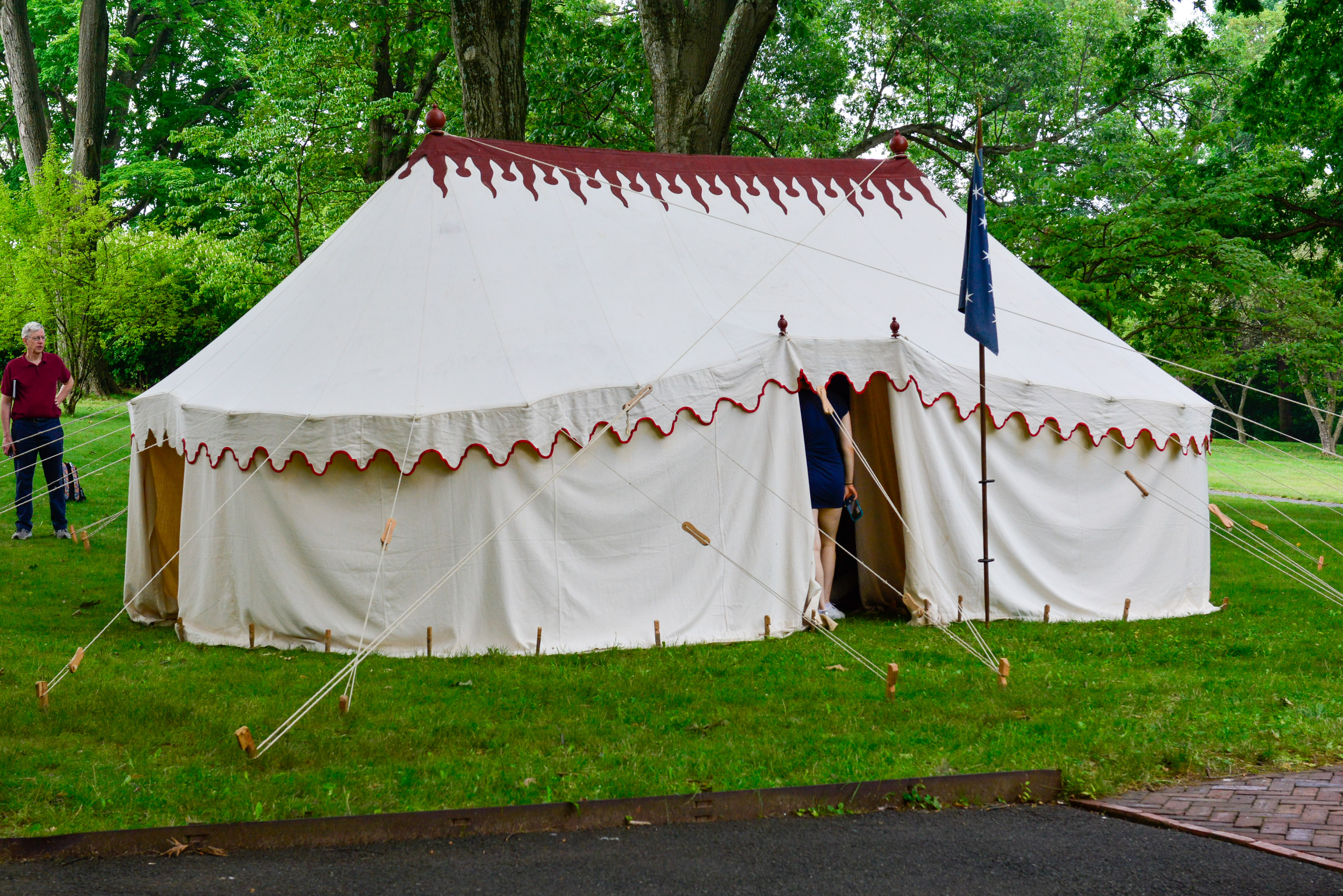 This image shows the handsewn replica linen tent with a silk replica commander in chief standard out front at Morristown National Historical Park.