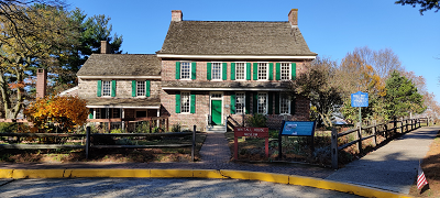 This image shows the Whitall house at Red Bank Battlefield with stone exterior and green shutters.